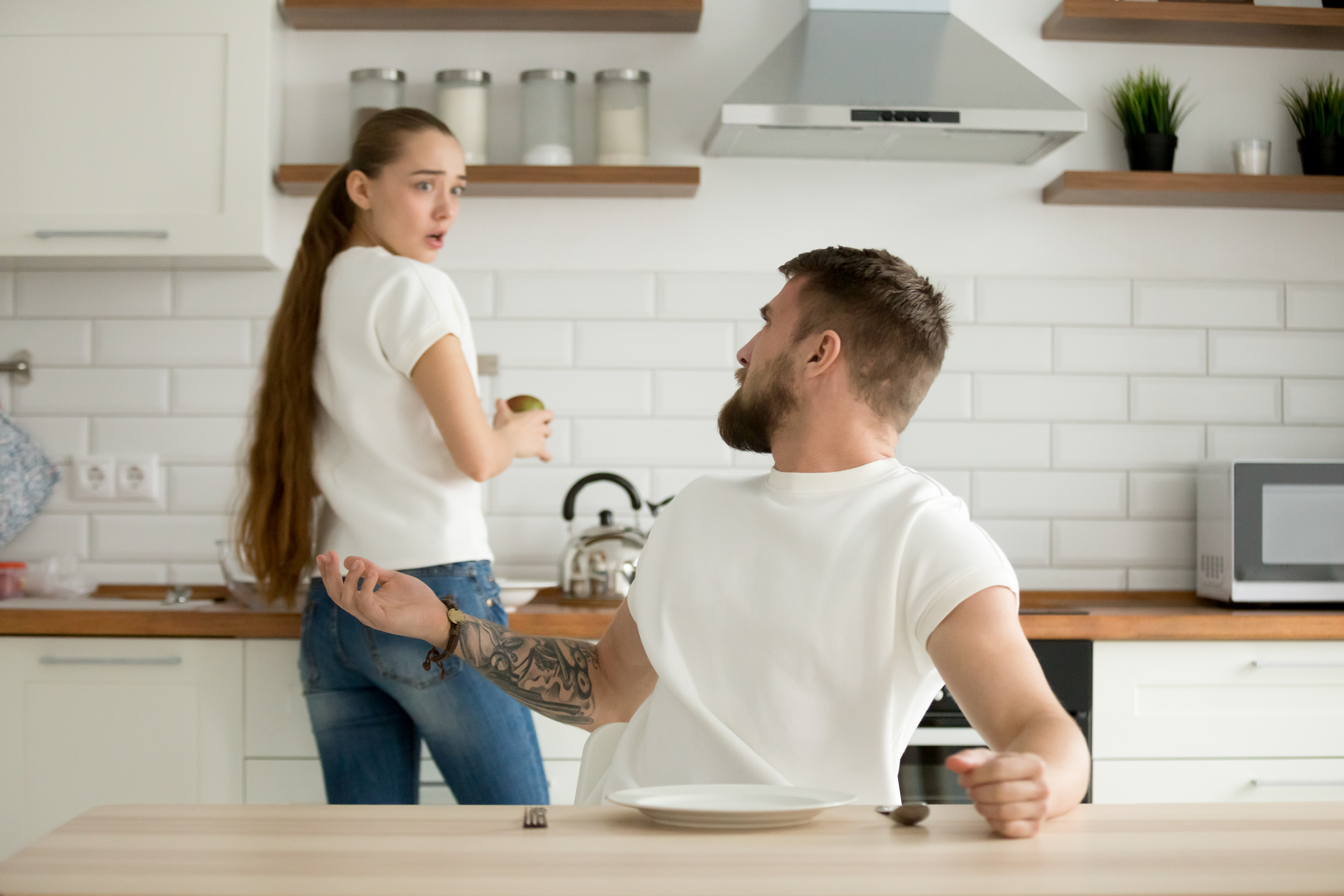 Angry husband and shocked wife arguing having conflict in kitche | Source: Getty Images