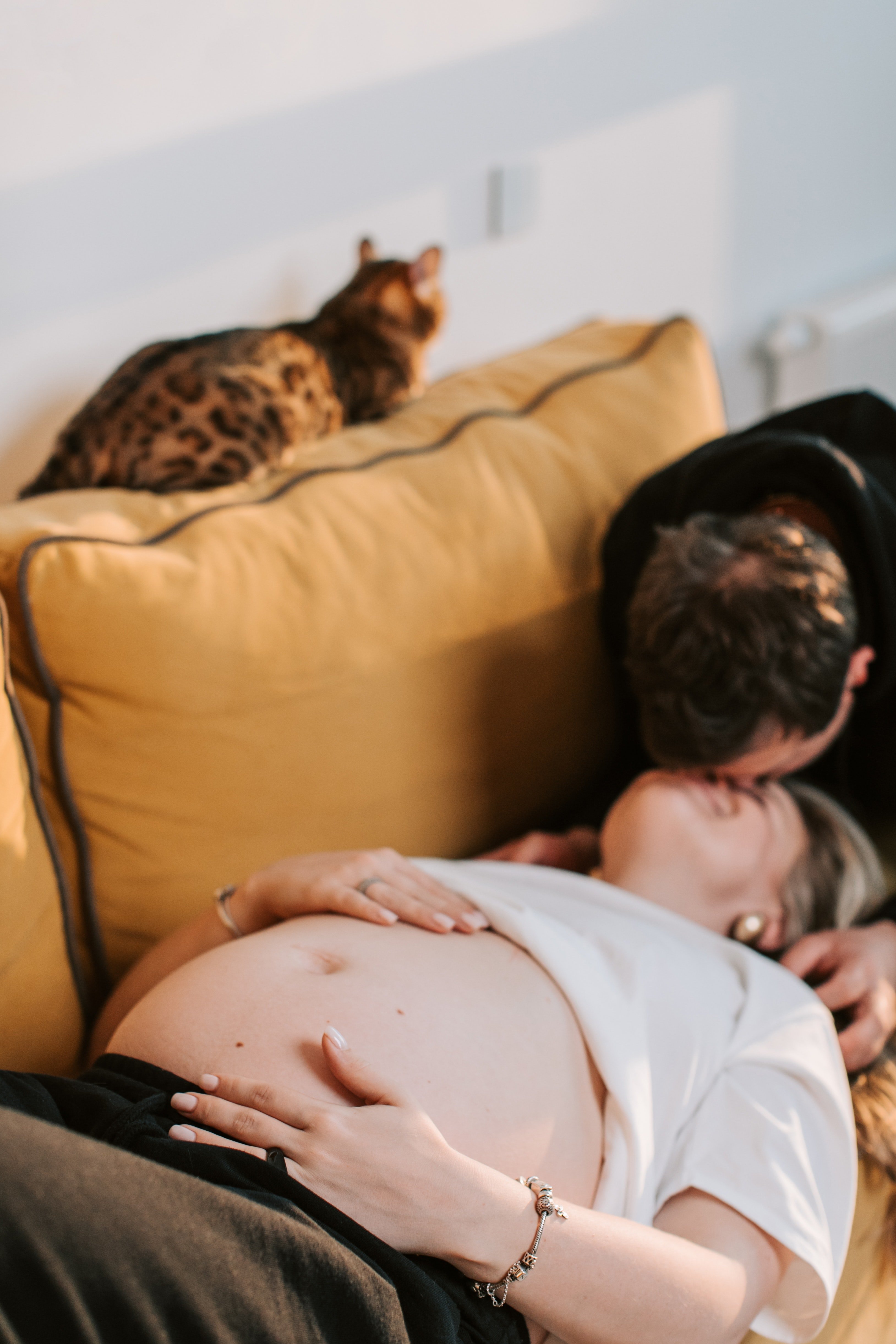 Una mujer embarazada recostada en un sofá junto a su pareja. | Foto: Pexels
