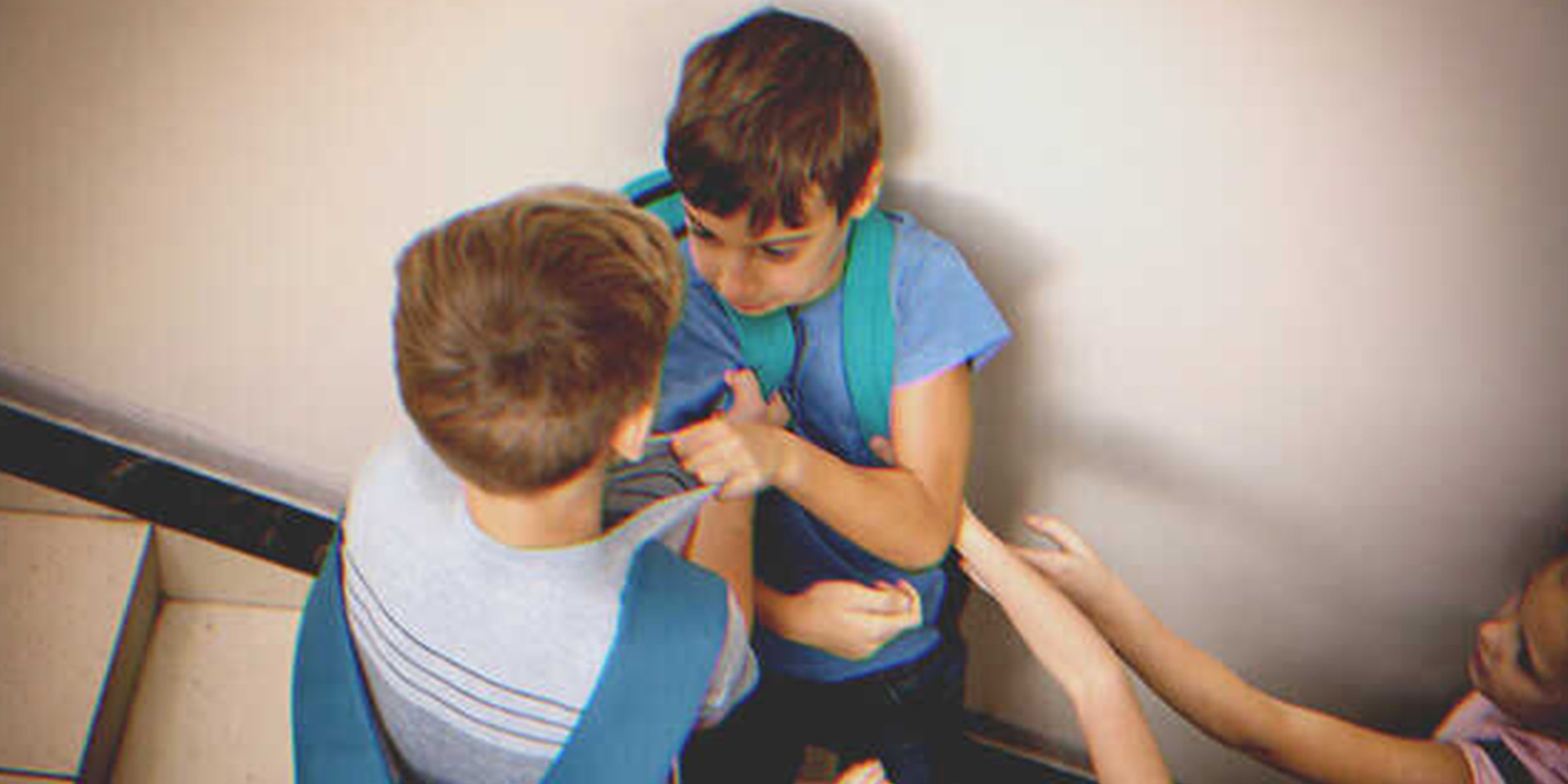 Timid little boy cornered by two other boys. | Source: Shutterstock