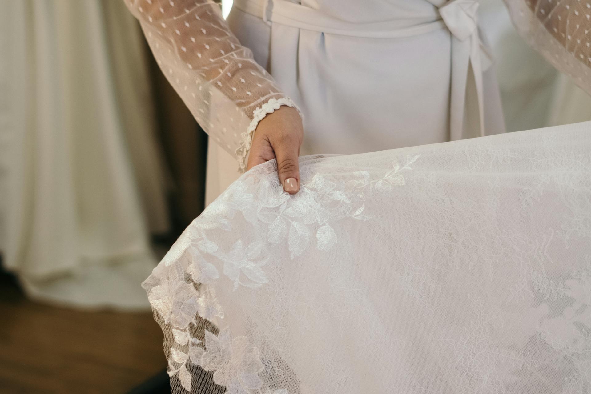 A woman holding a lace bridal dress | Source: Pexels