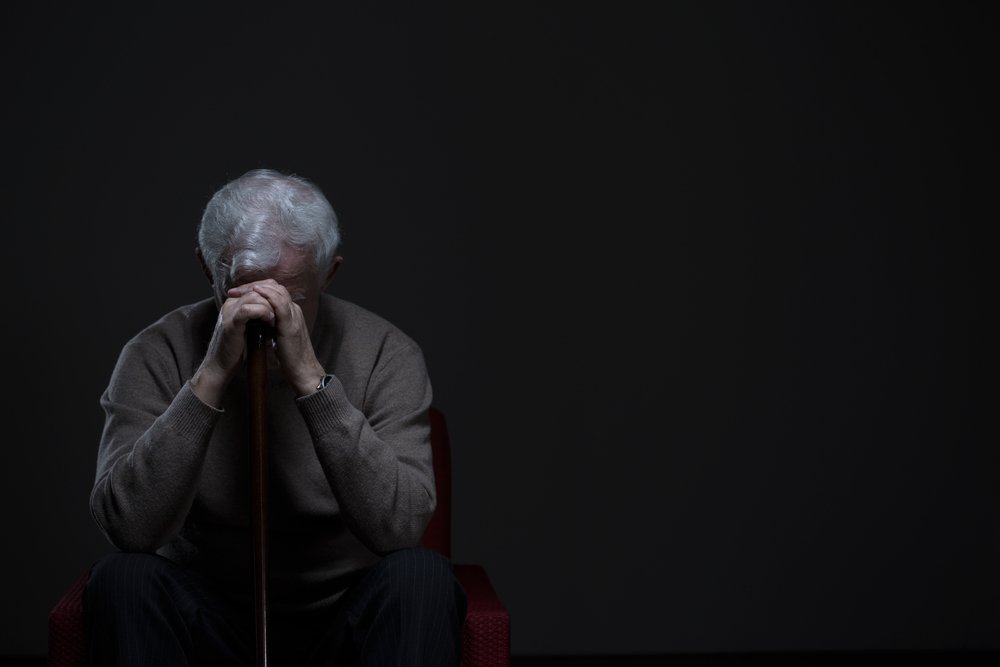 Anciano deprimido escondiendo su rostro con las manos. Fuente: Shutterstock