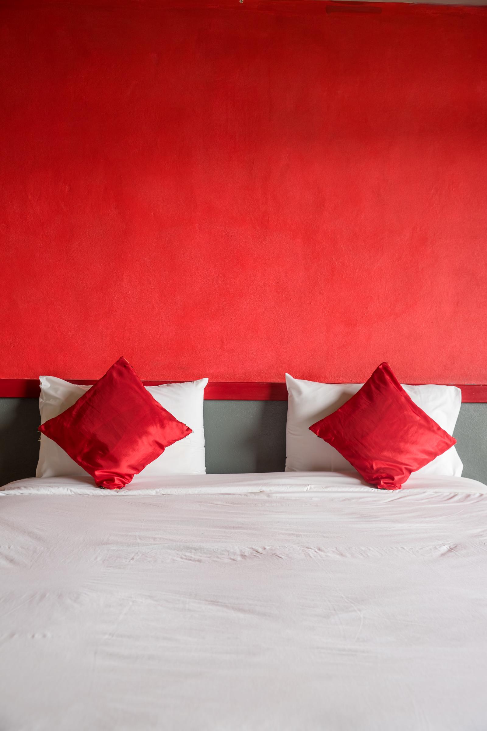 A bedroom with a bright red wall | Source: Shutterstock