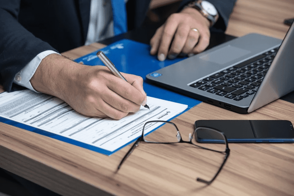 Man signing papers in an office | Photo: Pixabay