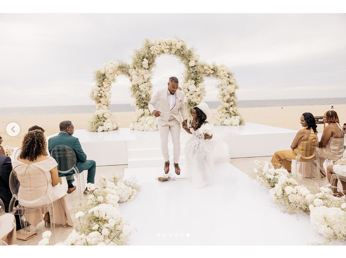 Simone Biles and Jonathan Owens perform the traditional "jumping the broom" ritual on their wedding, as seen in a post dated May 9, 2023 | Source: Instagram/simonebiles