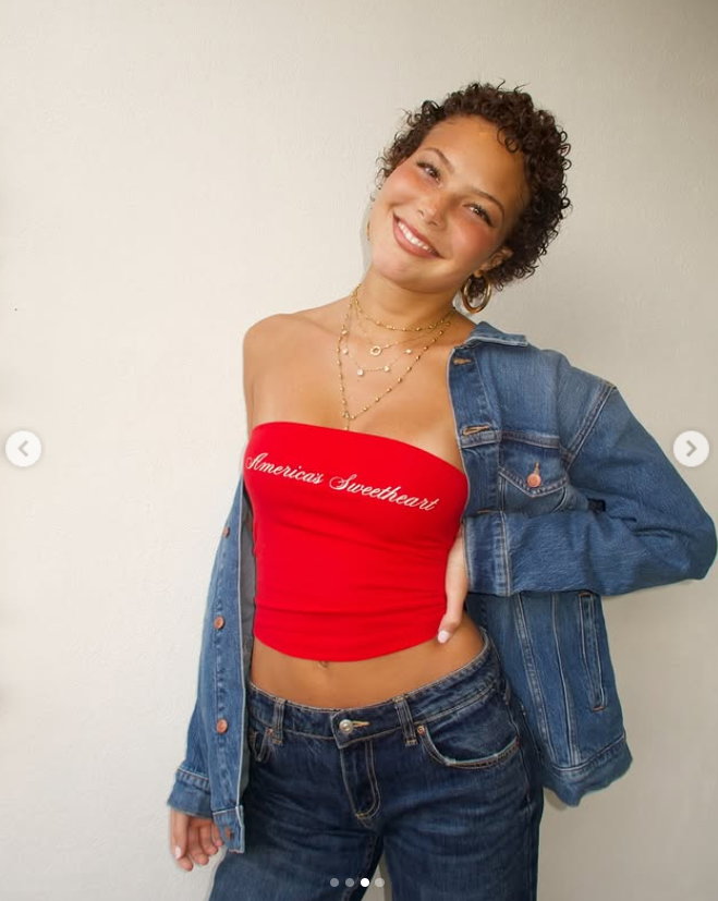 Isabella Strahan smiles in a red strapless top and denim jacket, showing off her short curls, as posted on May 24, 2025 | Source: Instagram/isabellastrahan