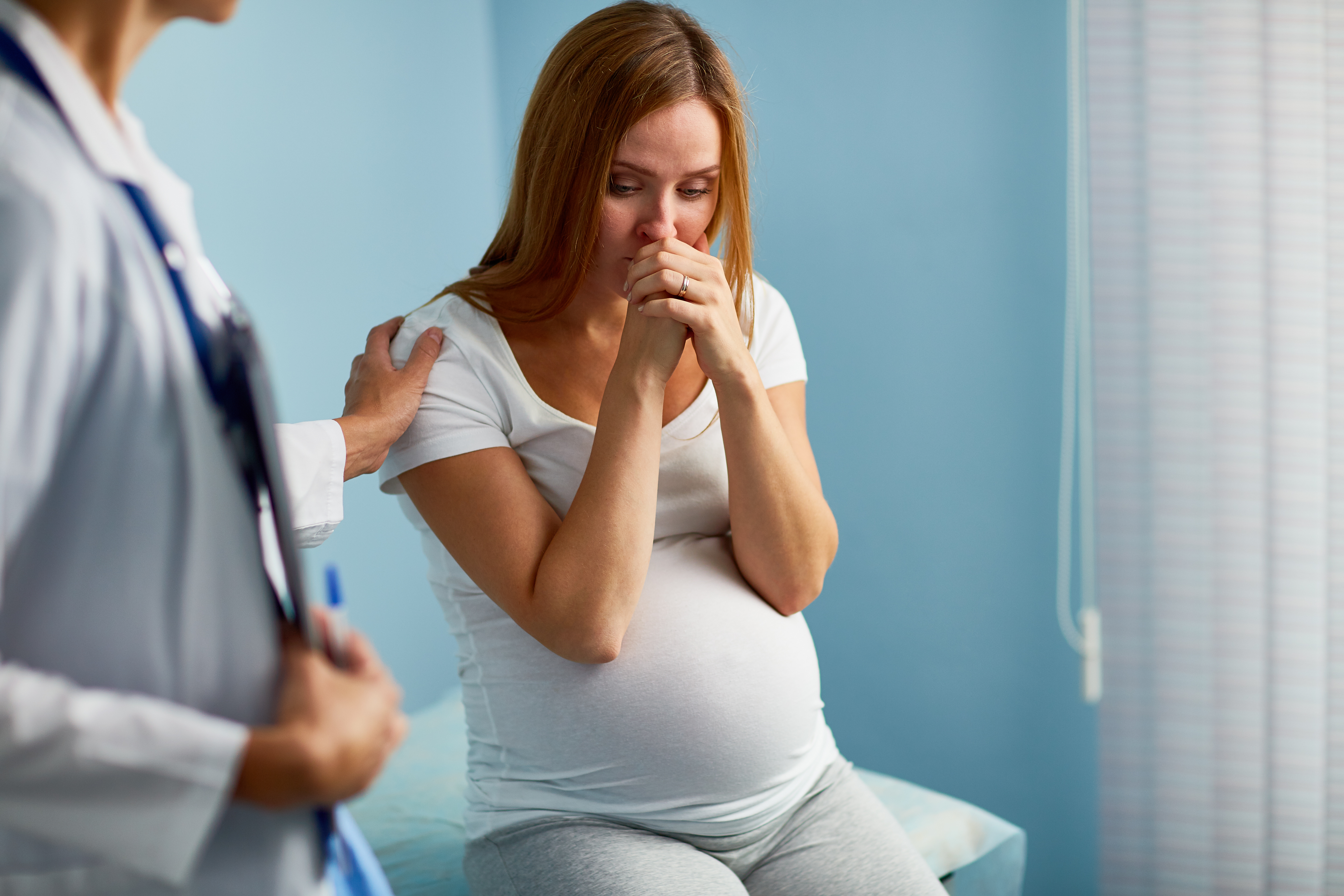 A pregnant woman at the doctor looking concerned | Source: Shutterstock