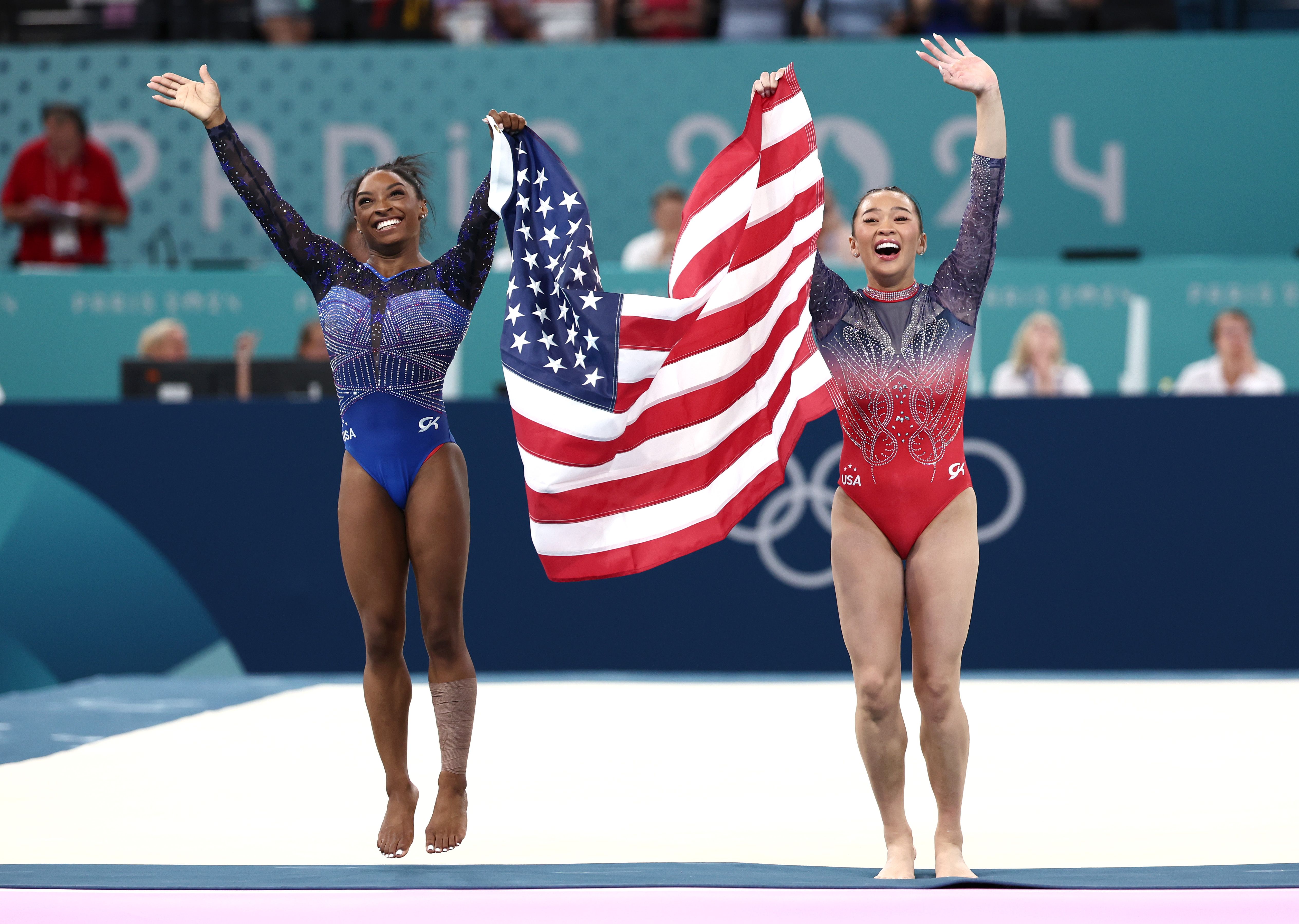 Simone Biles and Sunisa Lee celebrate with the American flag after competing in the Artistic Gymnastics Women's All-Around Final at the Olympic Games Paris 2024 in Paris, France, on August 1, 2024. | Source: Getty Images