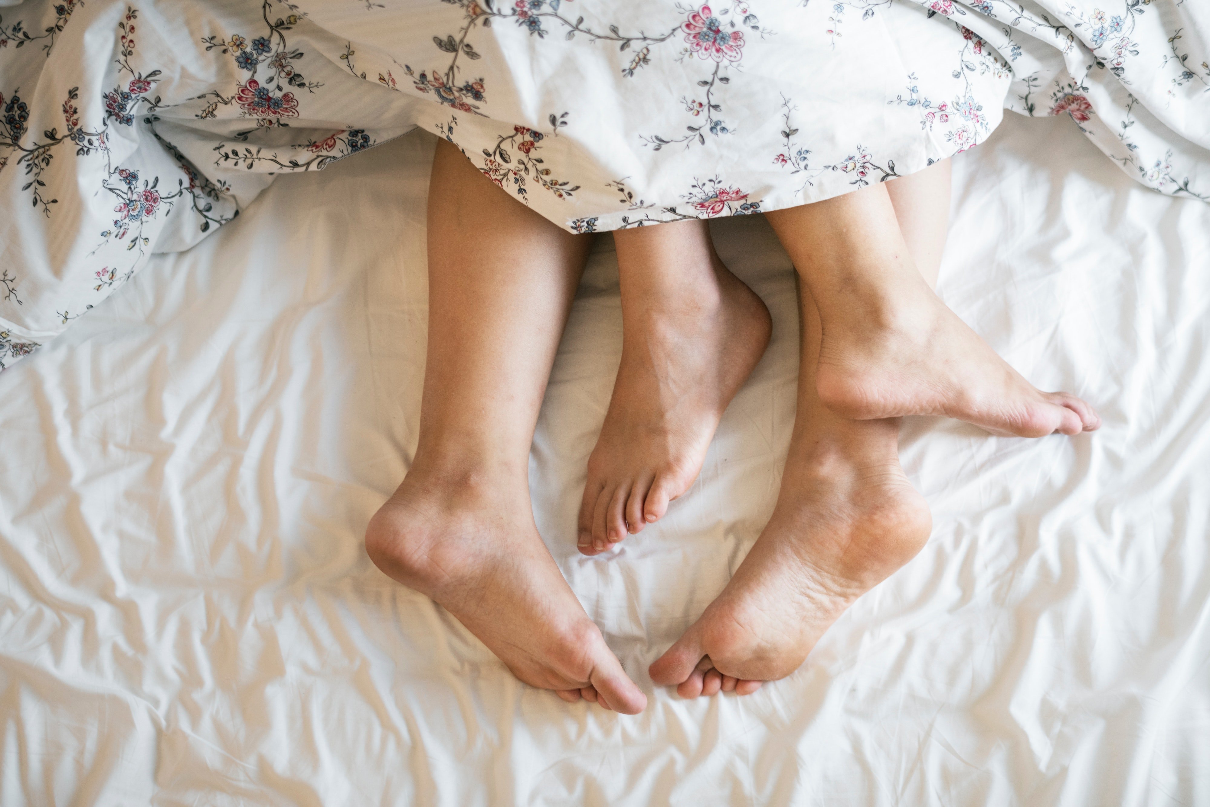 Adult legs sticking out of a duvet. | Source: Pexels