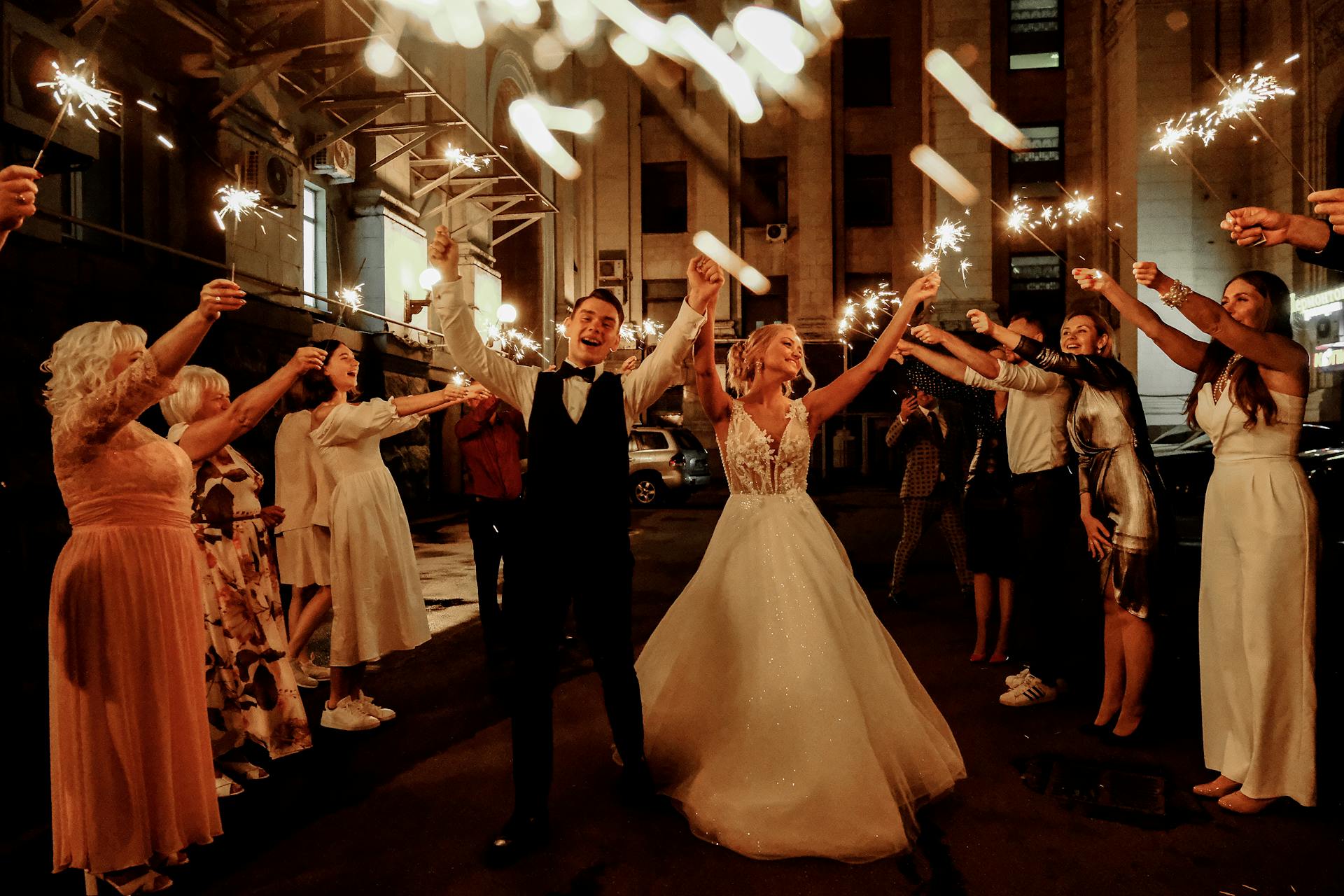 Happy friends and newlywed couple celebrating their wedding at night | Source: Pexels