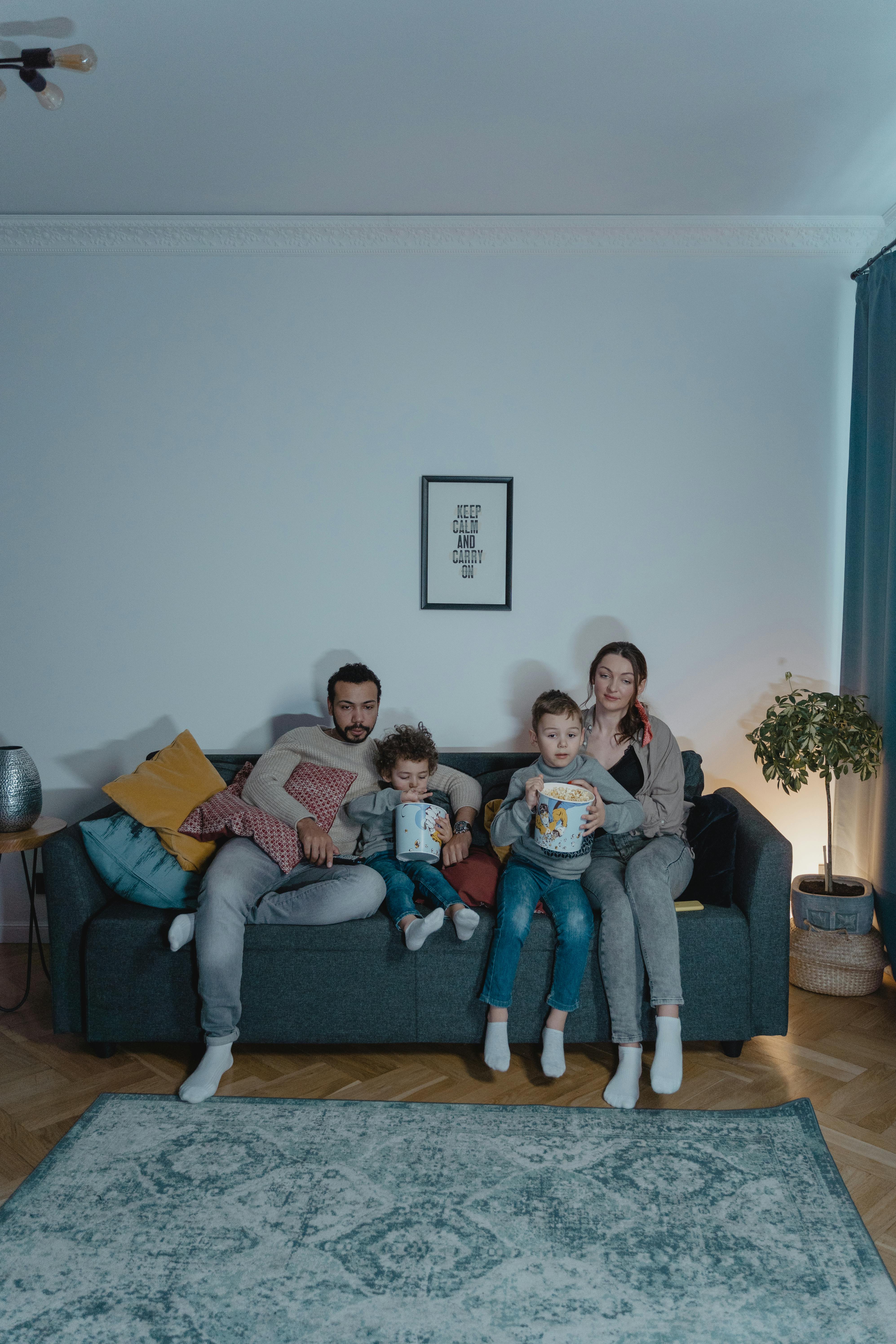 A couple sitting on the couch with their kids  | Source: Pexels