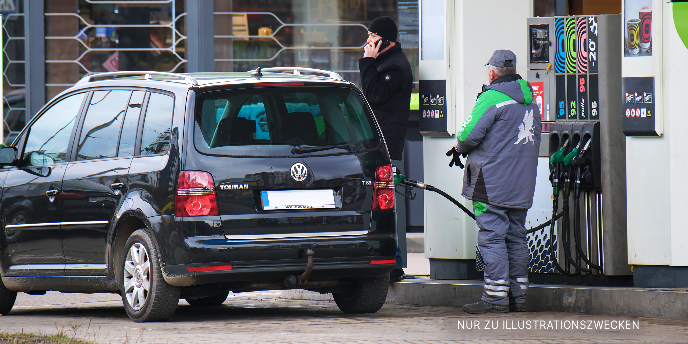 Ein Tankwart füllt Benzin in ein schwarzes Auto. | Quelle: Shutterstock