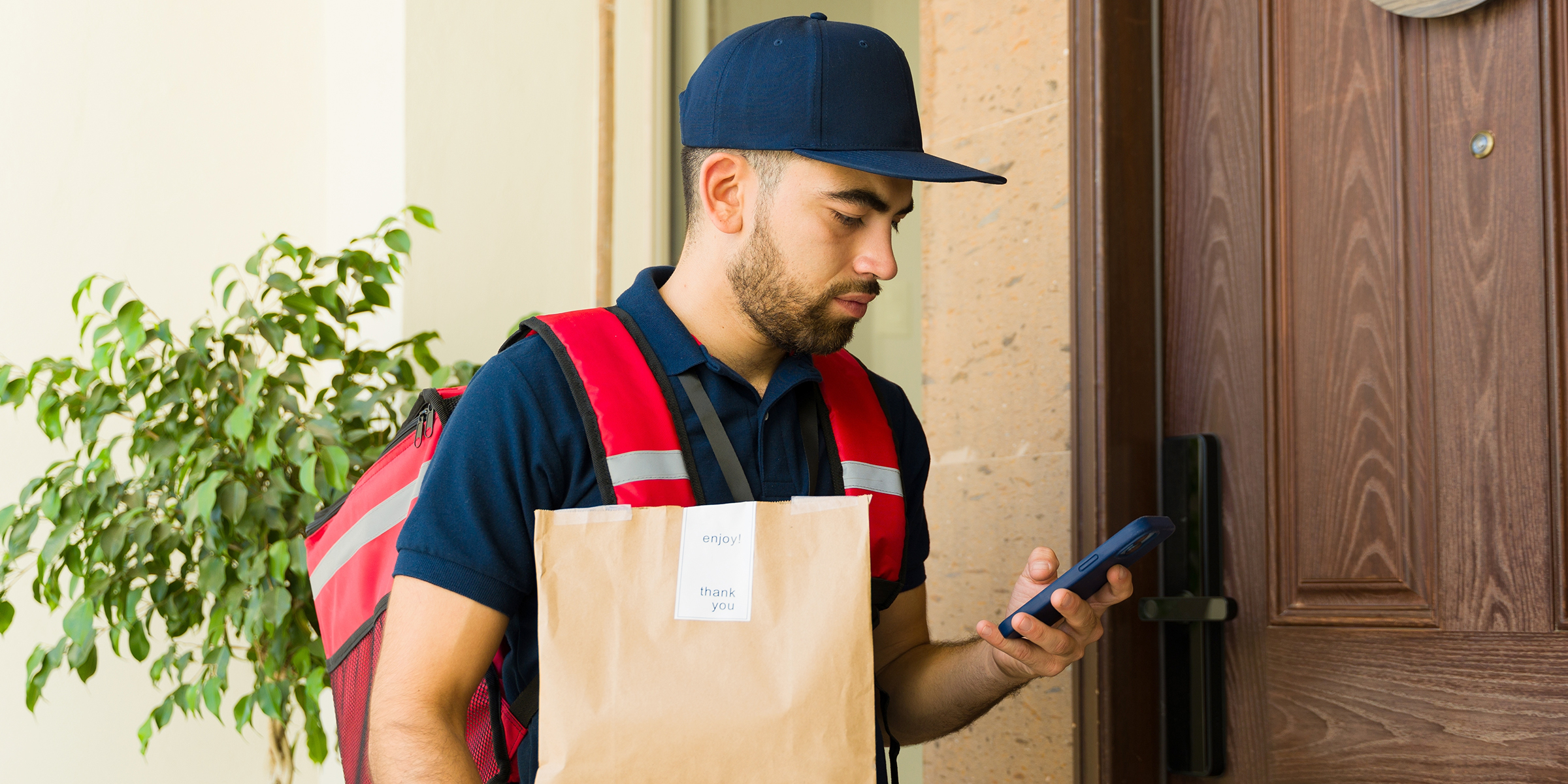 A delivery man with a phone | Source: Shutterstock