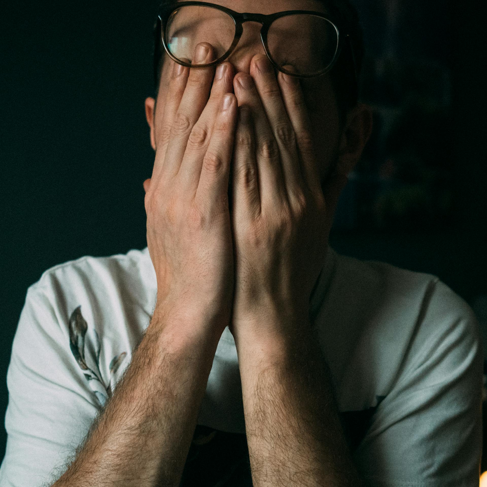 A startled man covering his face | Source: Pexels