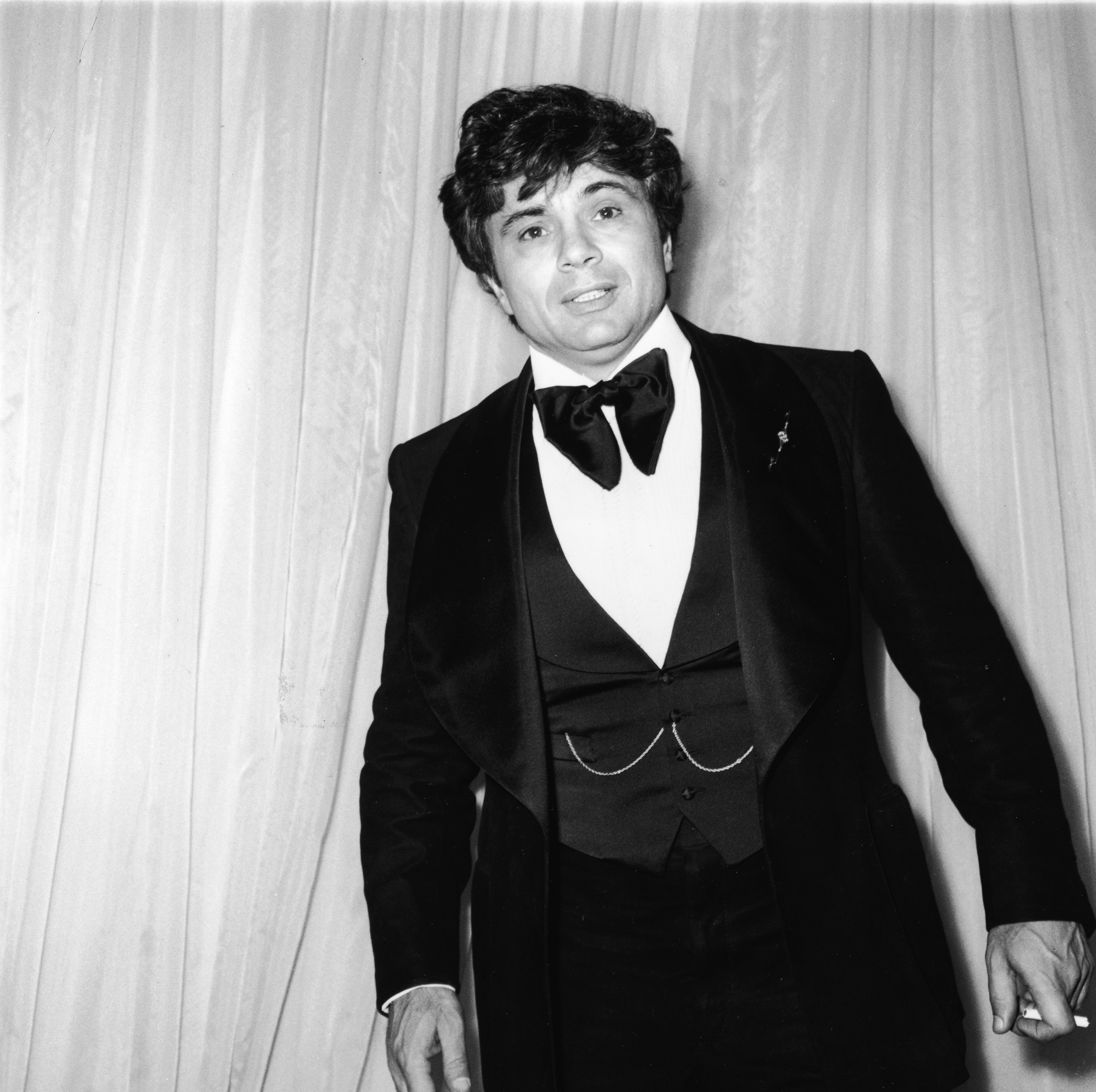 American actor Robert Blake stands at the Emmy Awards holding a cigarette in Hollywood, California in 1975 | Source: Getty Images