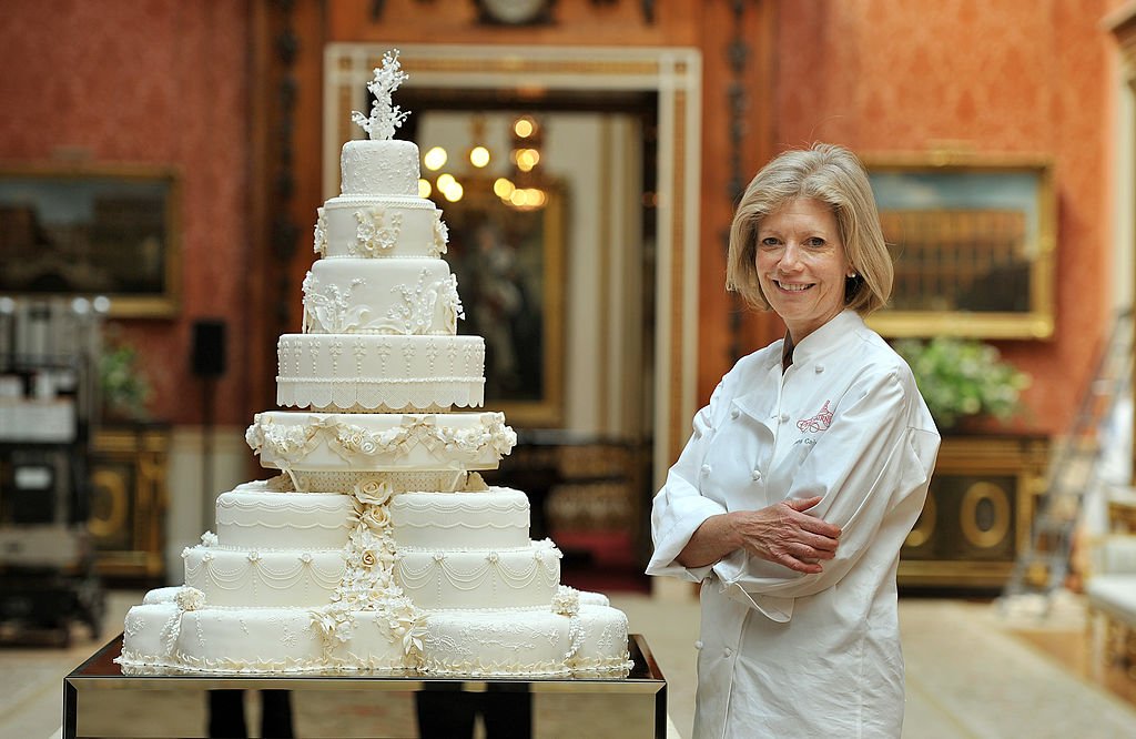 Fiona Cairns stands close to Prince William and Kate Middleton's Royal Wedding cake at the Buckingham Palace in London on April, 29, 2011. | Photo: Getty Images