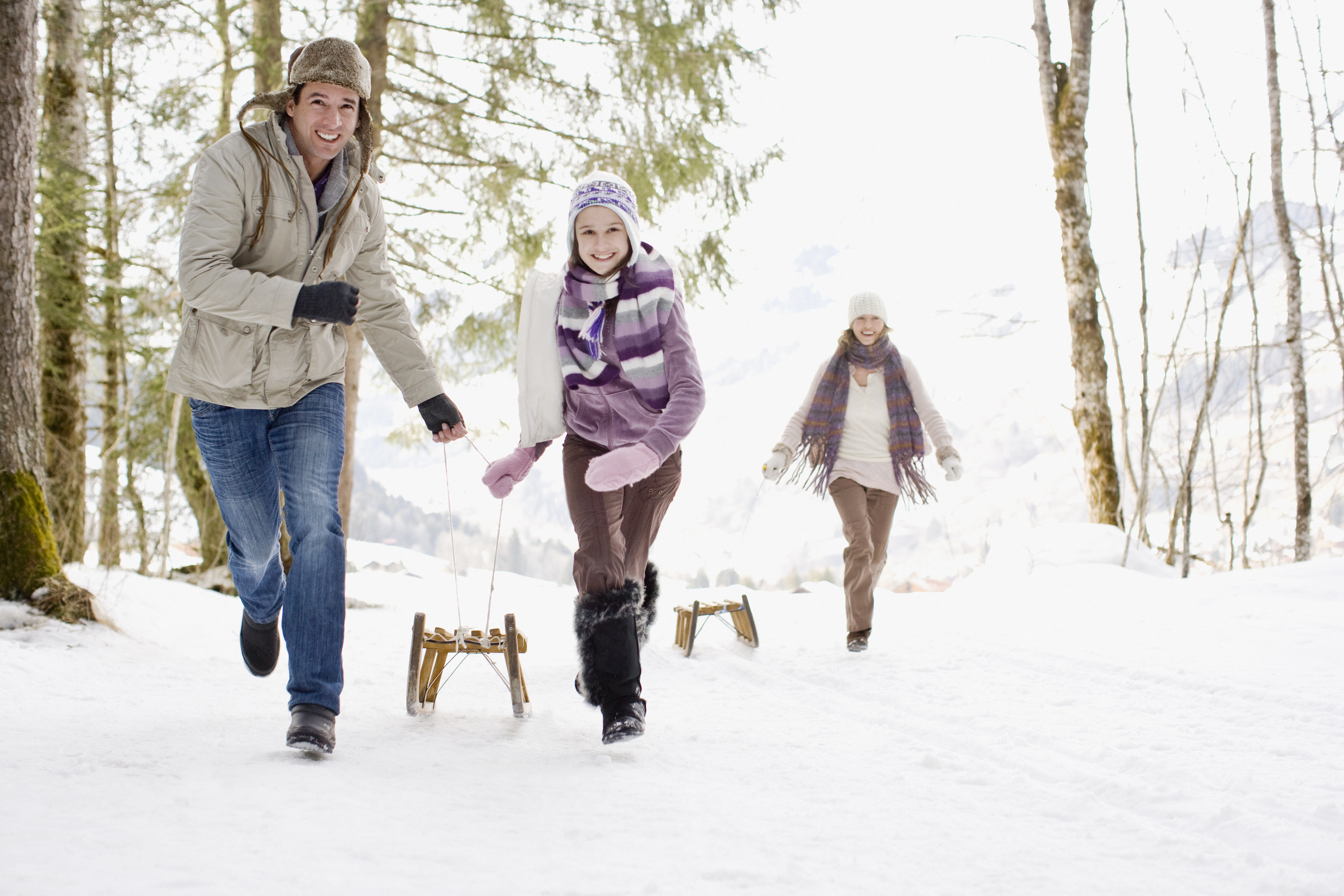 Family pulling sleds through snow | Source: Getty Images