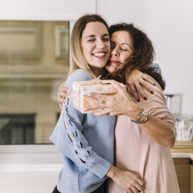 Woman hugging daughter while holding a present | Source: Freepik