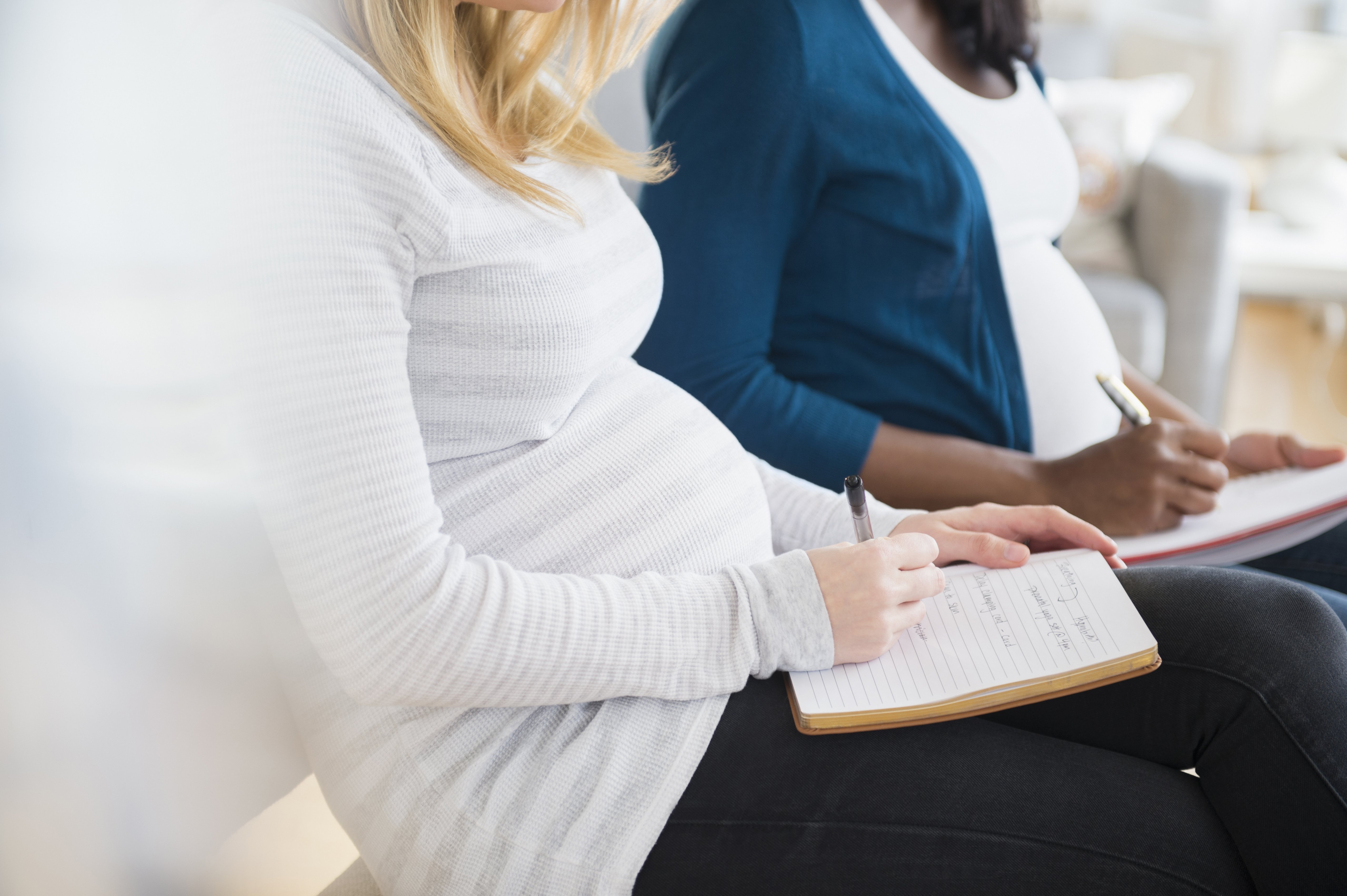 Pregnant women taking notes in class | Photo: Getty images