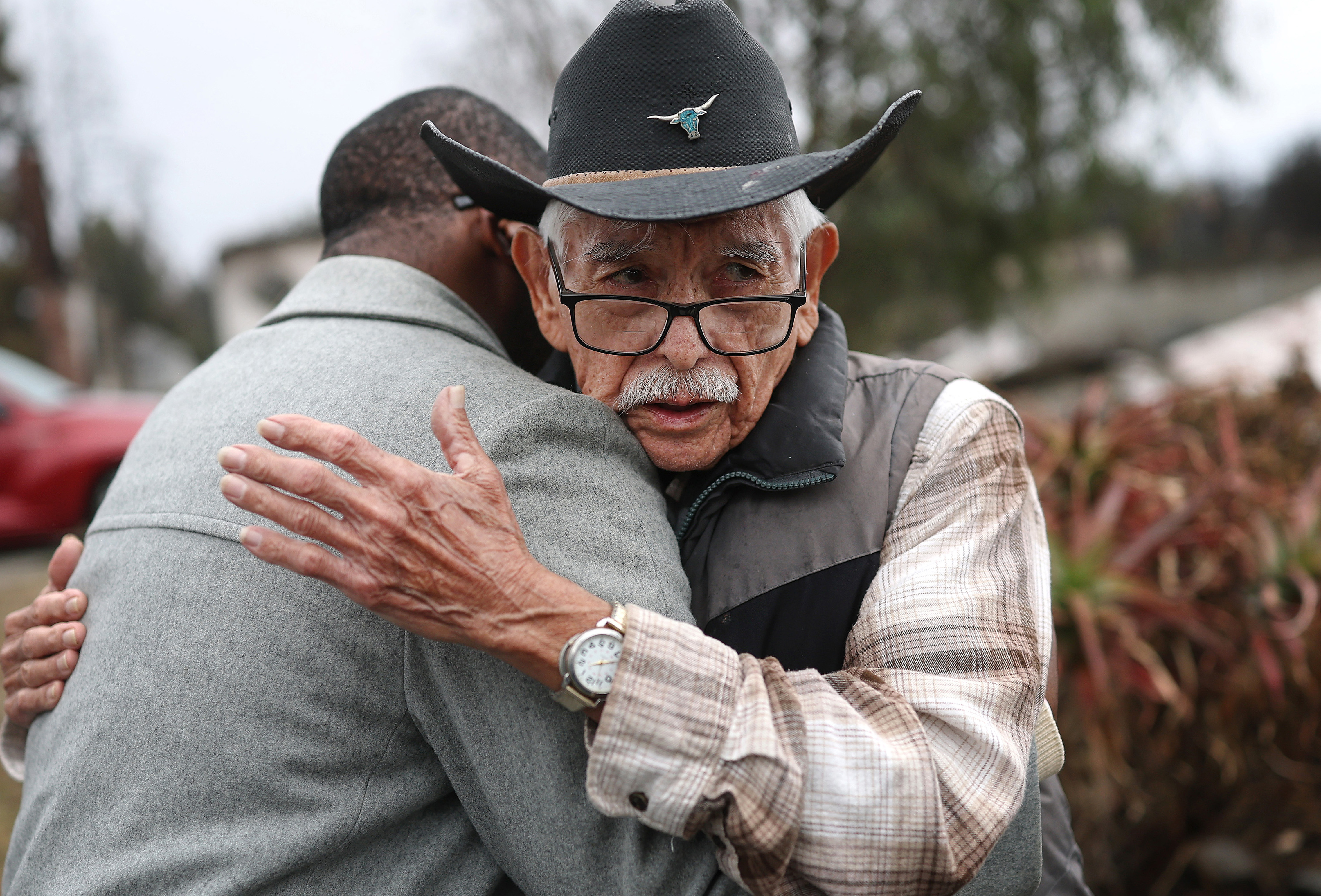 Civilians comforting each other as they look at the destruction caused by the wildfires in Altadena, California on February 5, 2025. | Source: Getty Images