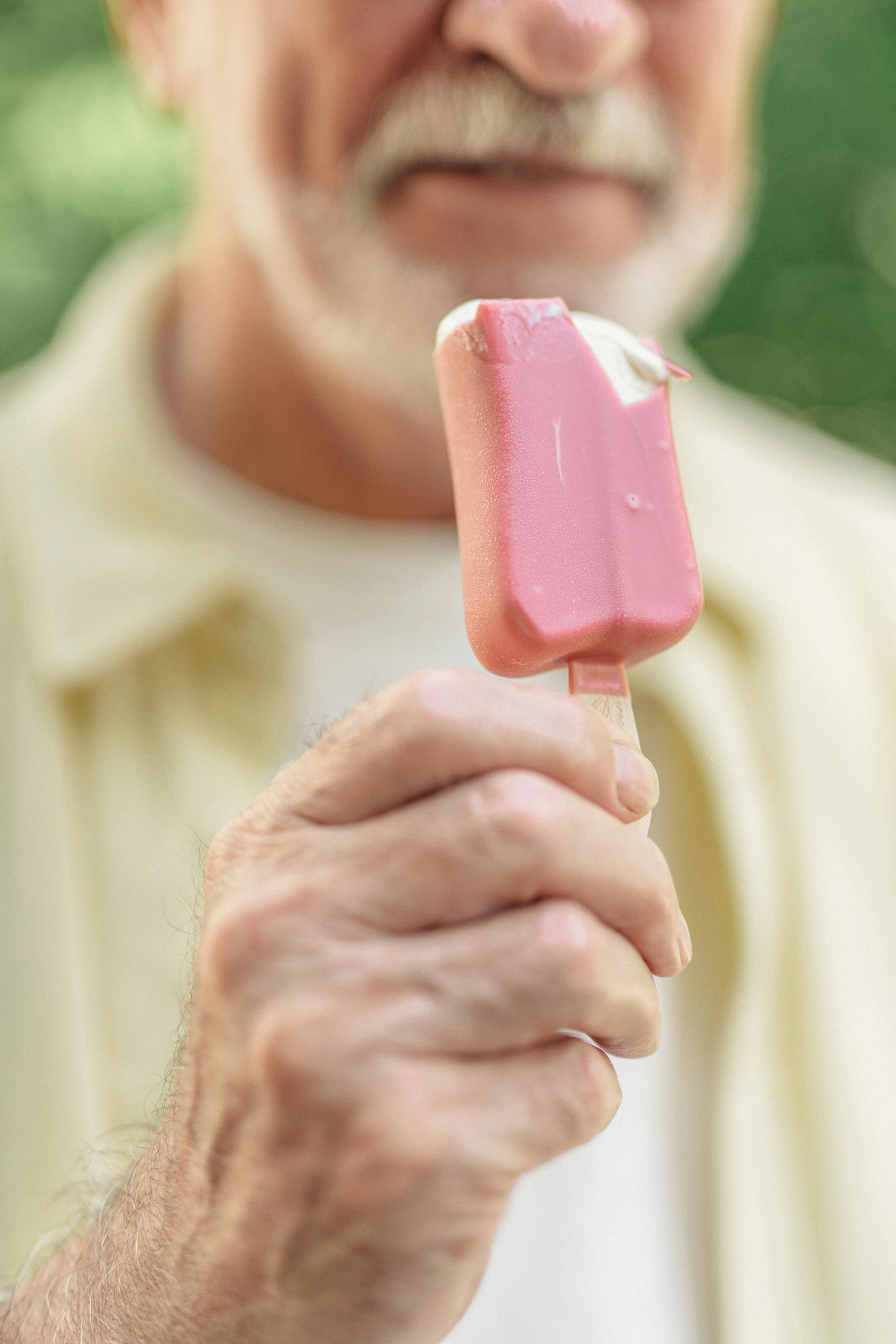 An older man holding an ice pop | Source: Pexels