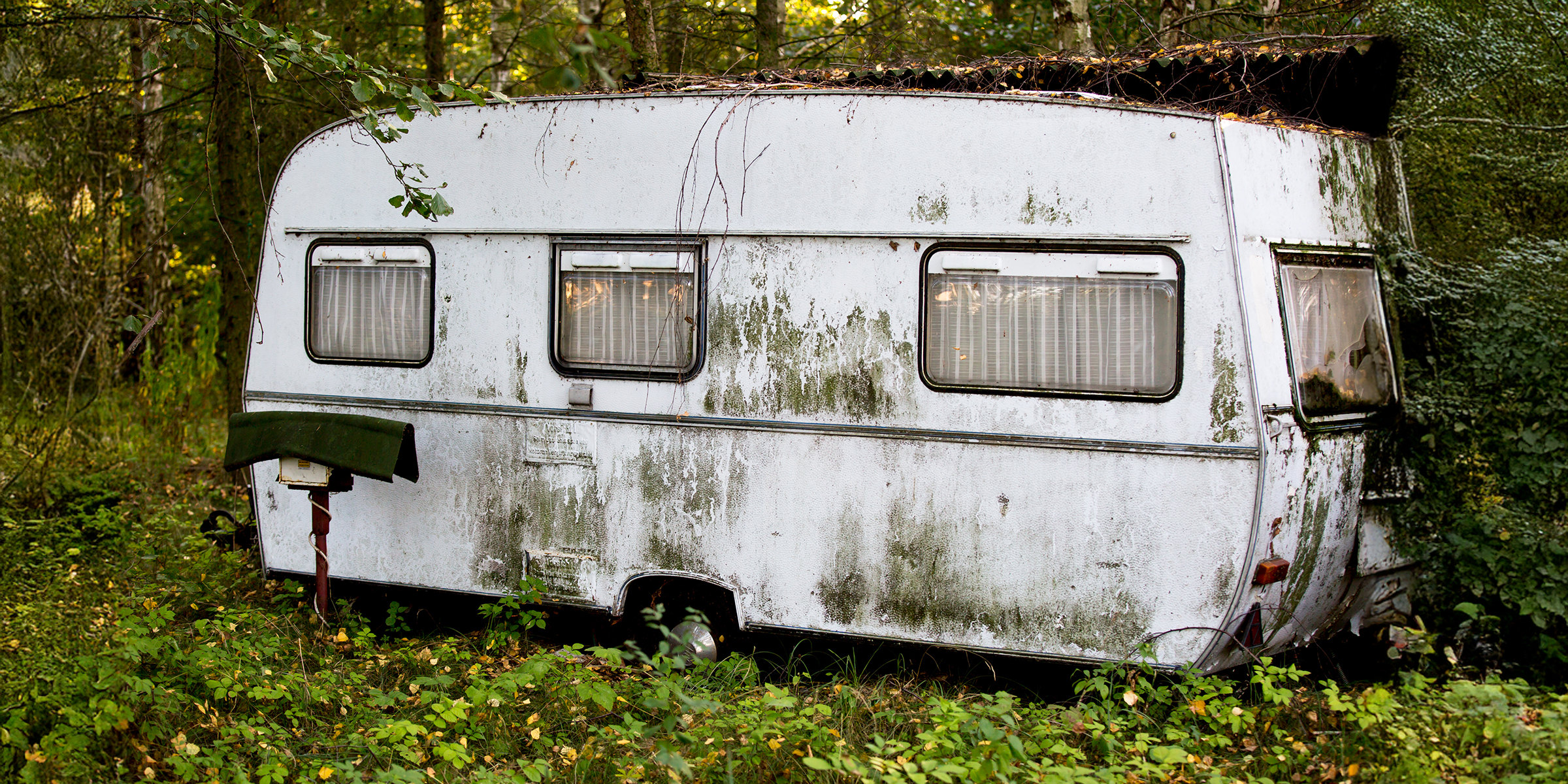 An old trailer in the woods | Source: Midjourney