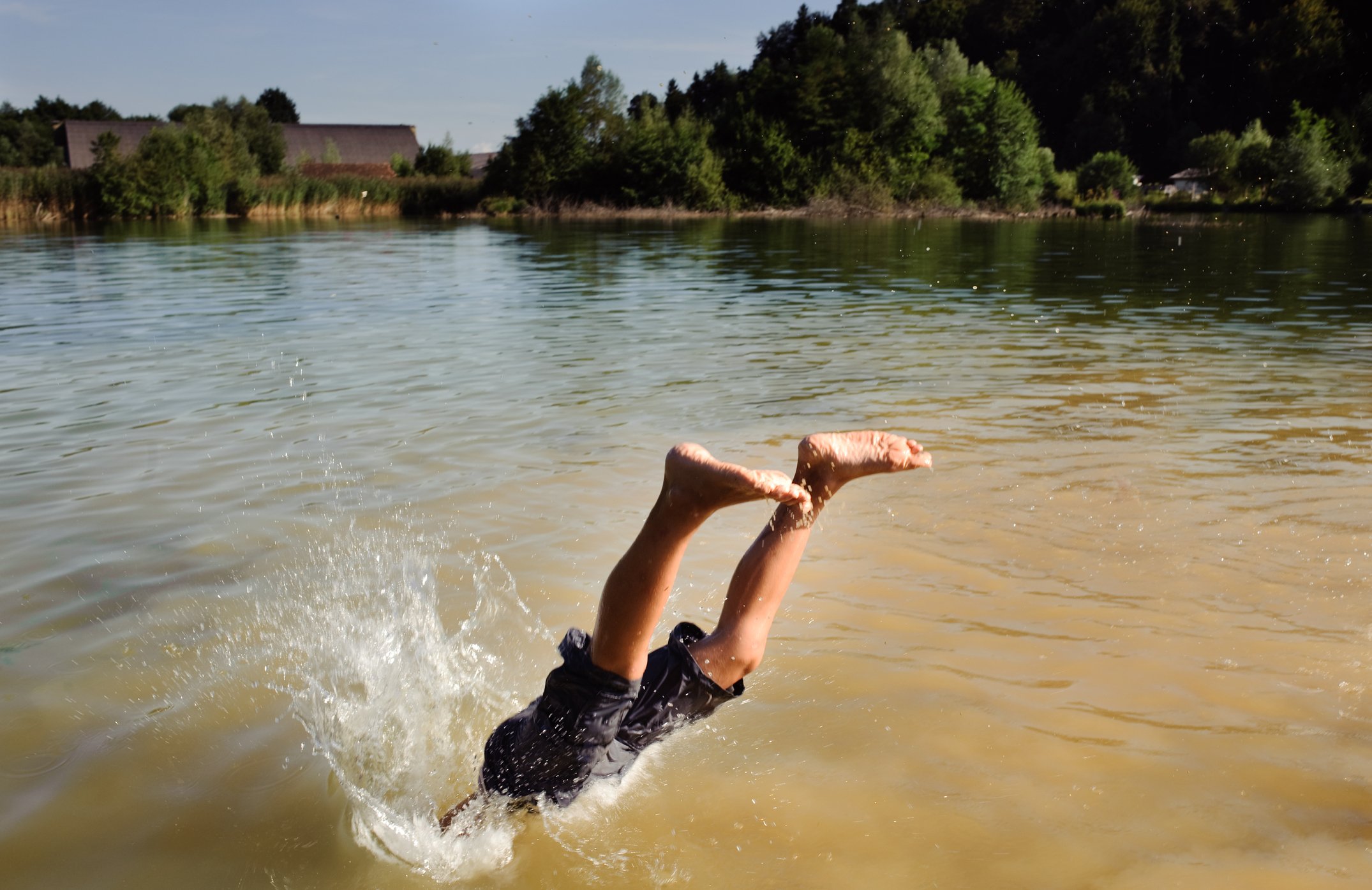 Ein Junge taucht in einen See | Quelle: Getty Images