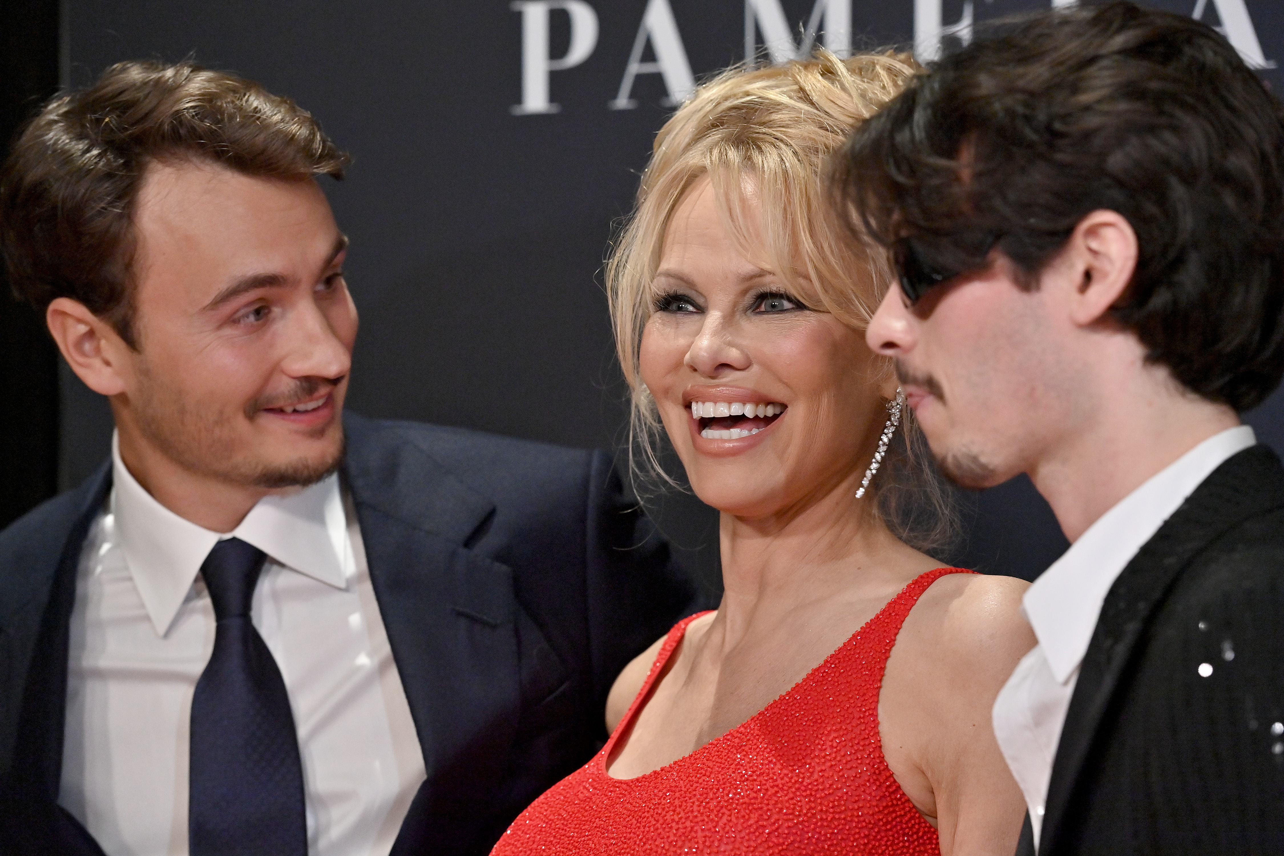 Pamela Anderson smiles between her sons, Brandon and Dylan Lee, at the Netflix premiere of "Pamela, A Love Story" in California on January 30, 2023 | Source: Getty Images