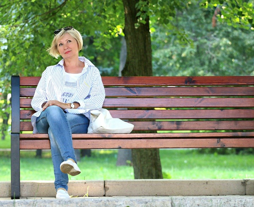 Mujer sentada en un banquillo mientras está pensativa en un parque. | Imagen: Pixabay Mujer sentada en un banquillo mientras está pensativa en un parque. | Imagen: Pixabay