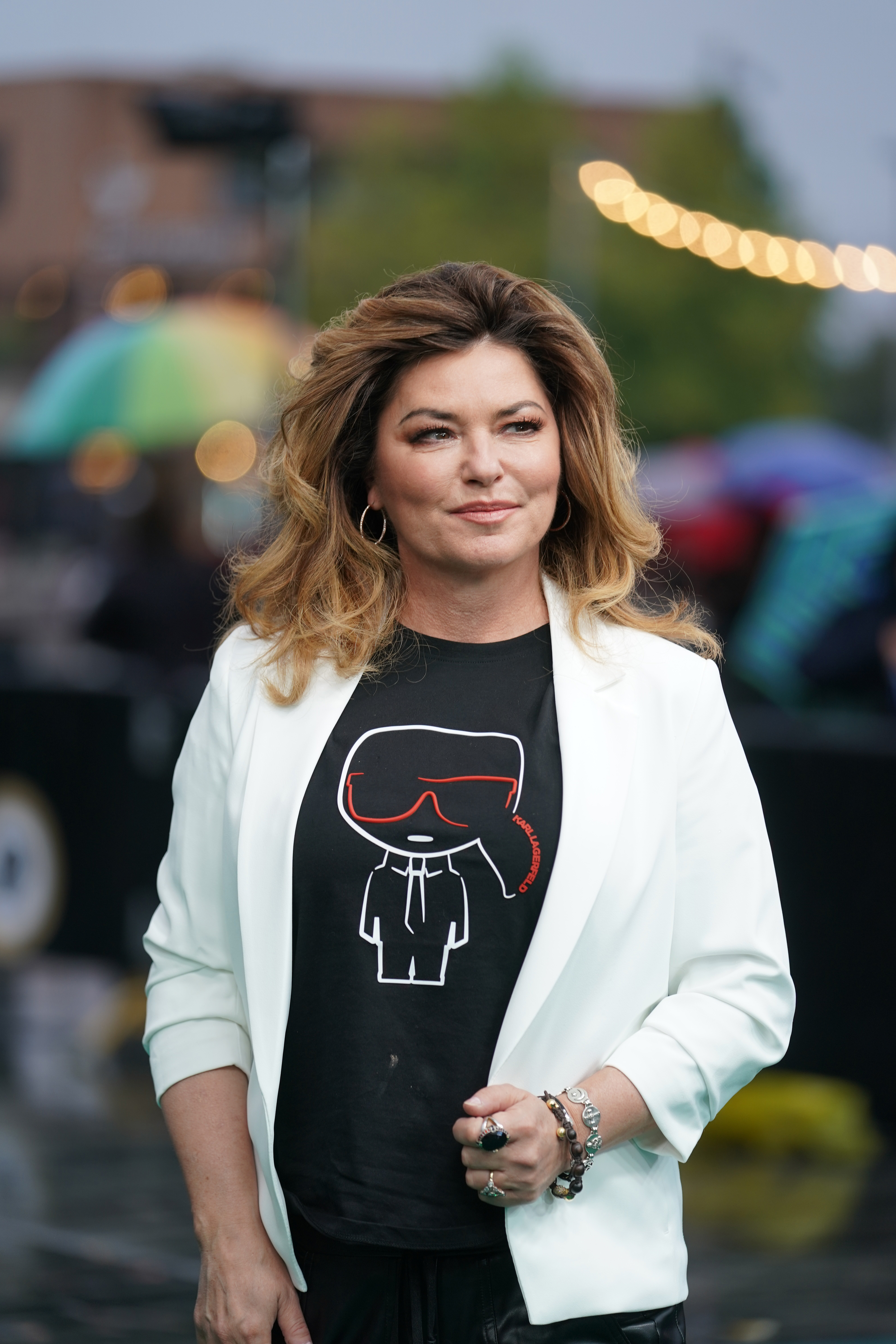 Posing outdoors at Kino Corso during the 2020 Zurich Film Festival, a glowing Shania Twain complemented her laid-back graphic tee with stacked wristwear and her signature soft blowout. | Source: Getty Images