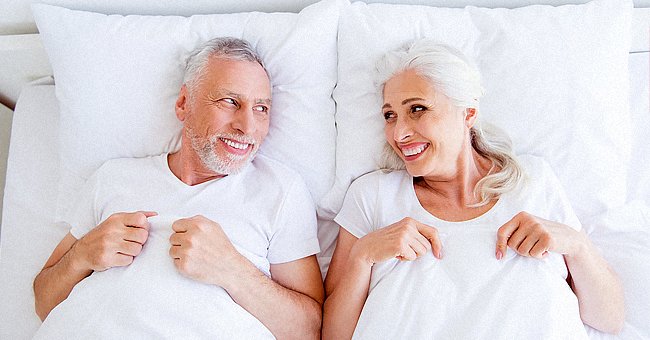 An older couple lying in bed. | Photo: Shutterstock
