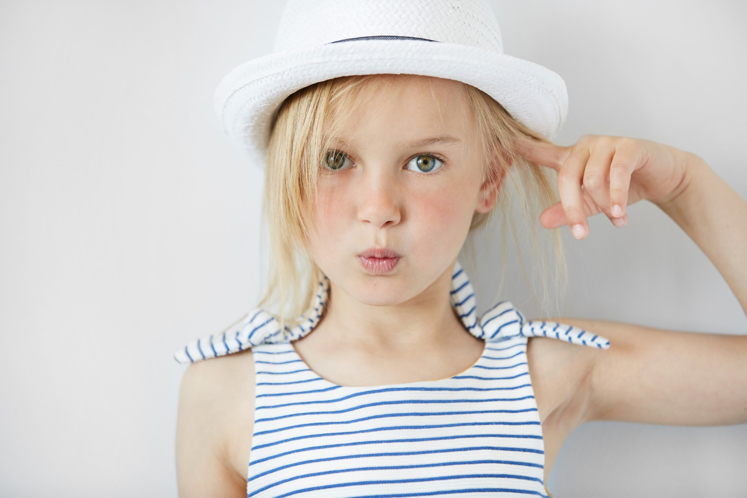 An expressive young girl wearing a hat | Source: Freepik