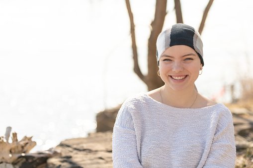 A young woman with cancer smiles into the camera | Photo: Getty Images