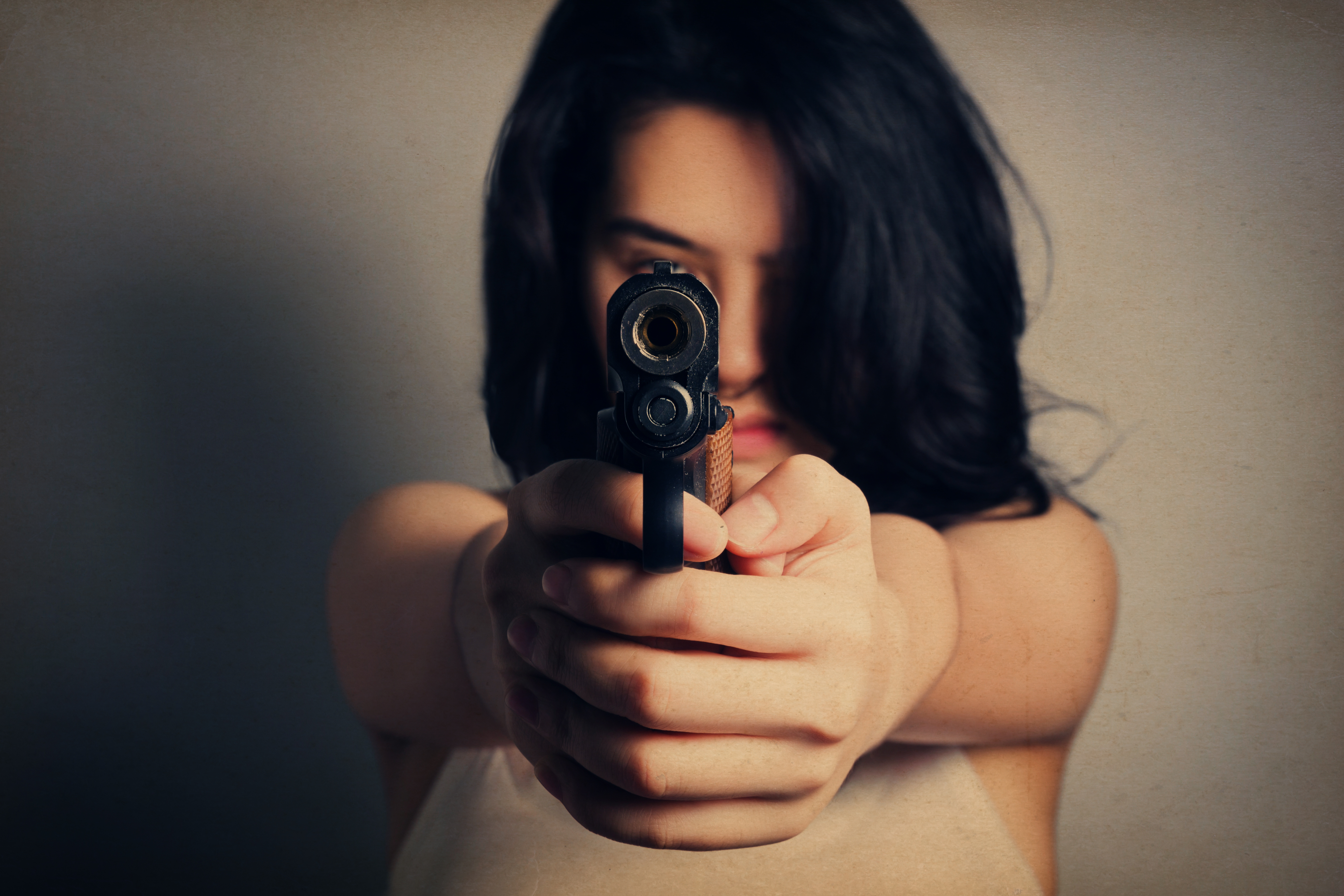 Woman aiming a gun | Source: Shutterstock