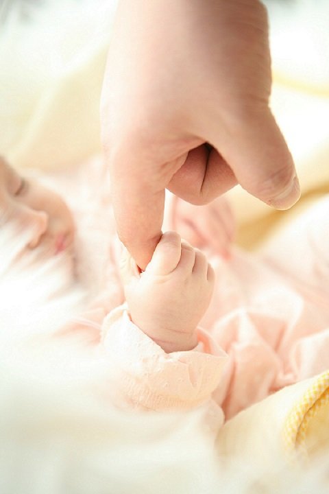 A newborn baby holding his father's index finger. | Photo: Pixabay.