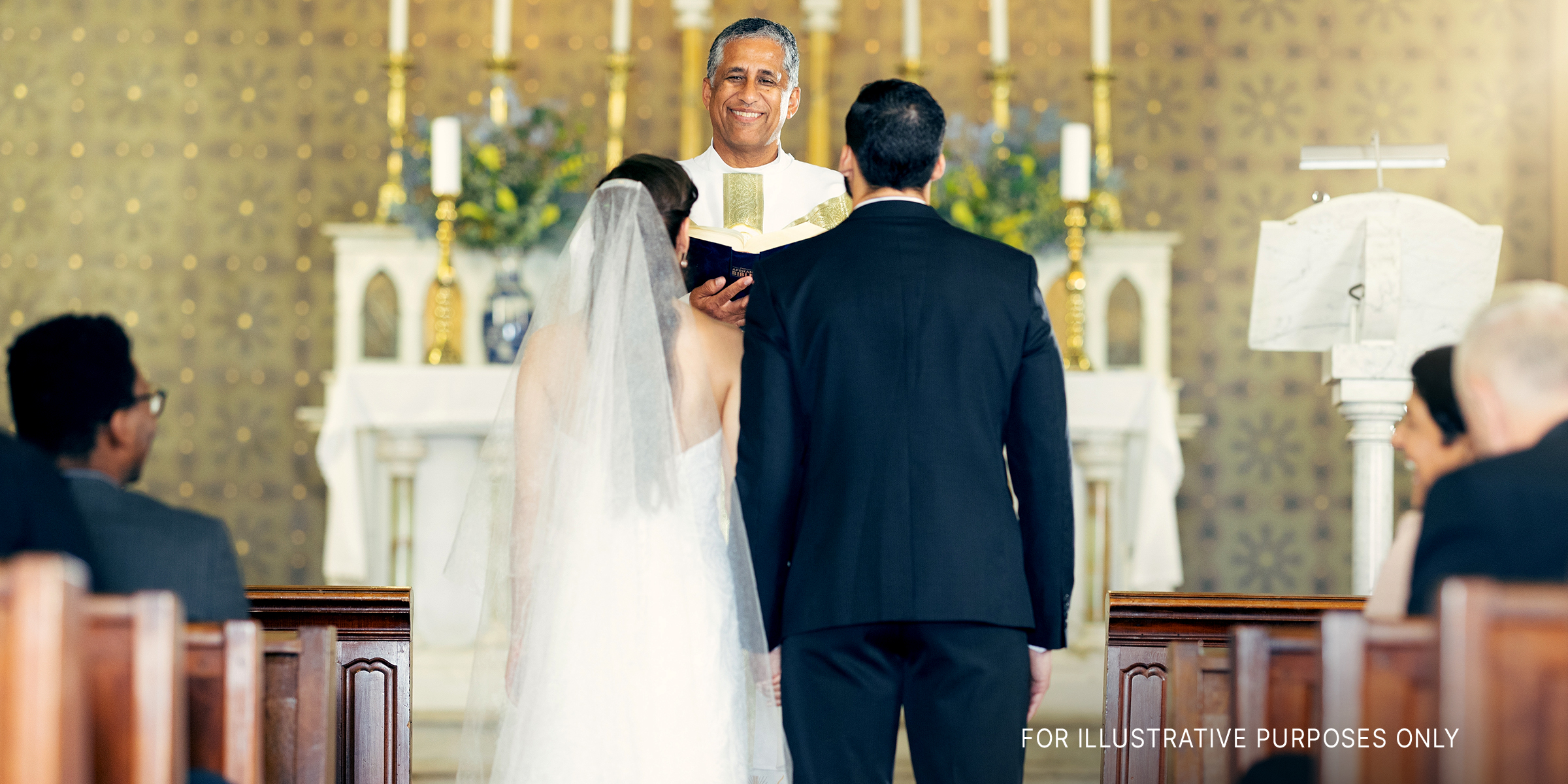 Couple standing before priest in chapel | Source: Shutterstock