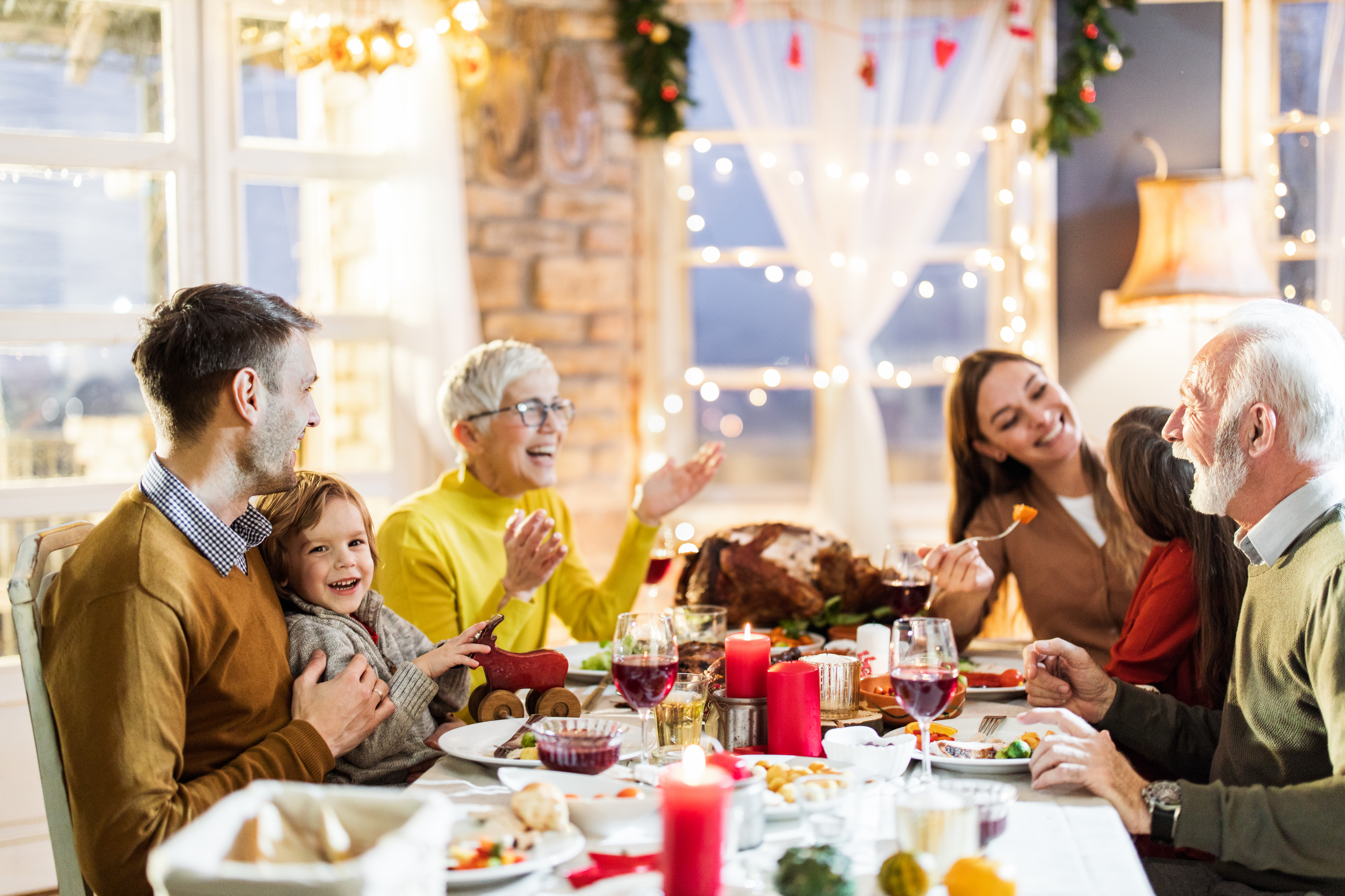 Happy multi-generation family enjoying in conversation during Thanksgiving lunch at dining table | Source: Getty Images