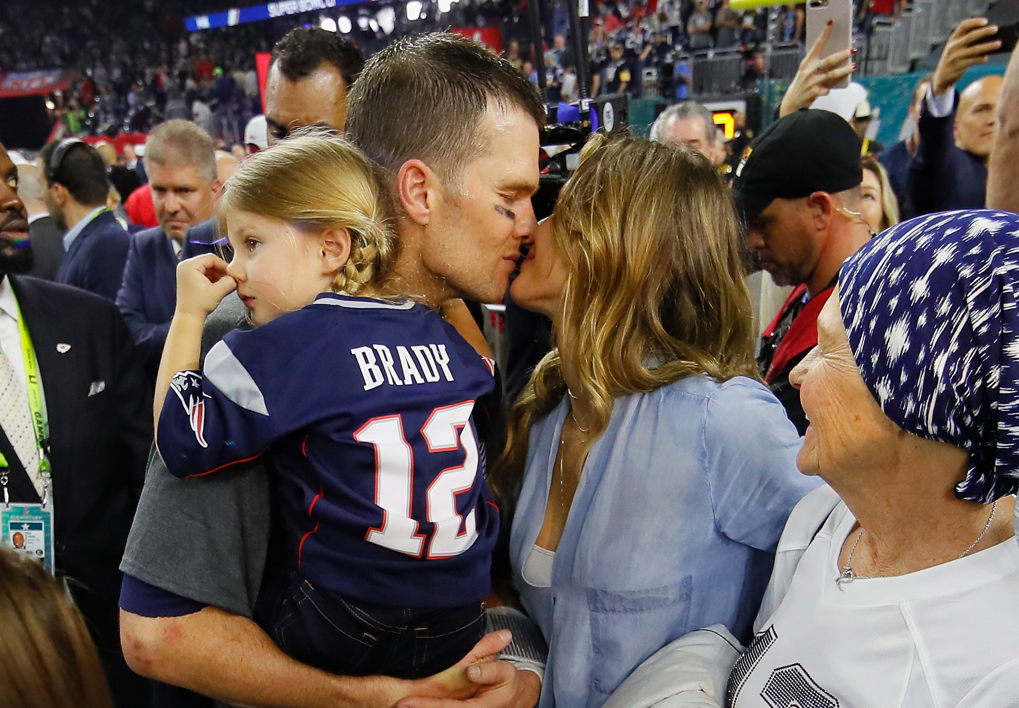 Tom Brady holds Vivian Brady as he kisses Gisele Bündchen in Houston, Texas on February 5, 2017 | Source: Getty Images
