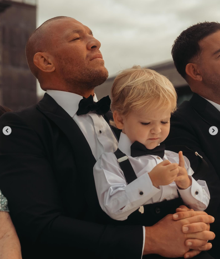 Conor McGregor carries his son, Rian, at Terry Kavanagh and Erin McGregor's wedding on August 17, 2024 | Source: Instagram/thenotoriousmma