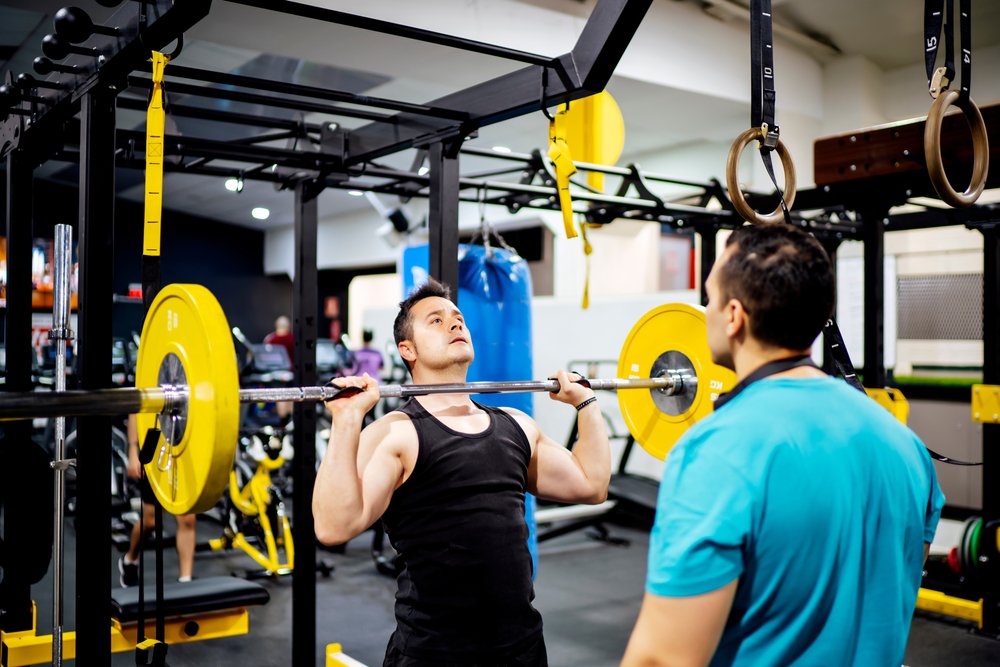 A personal trainer and his client working it out in the gym. | Photo: Shutterstock