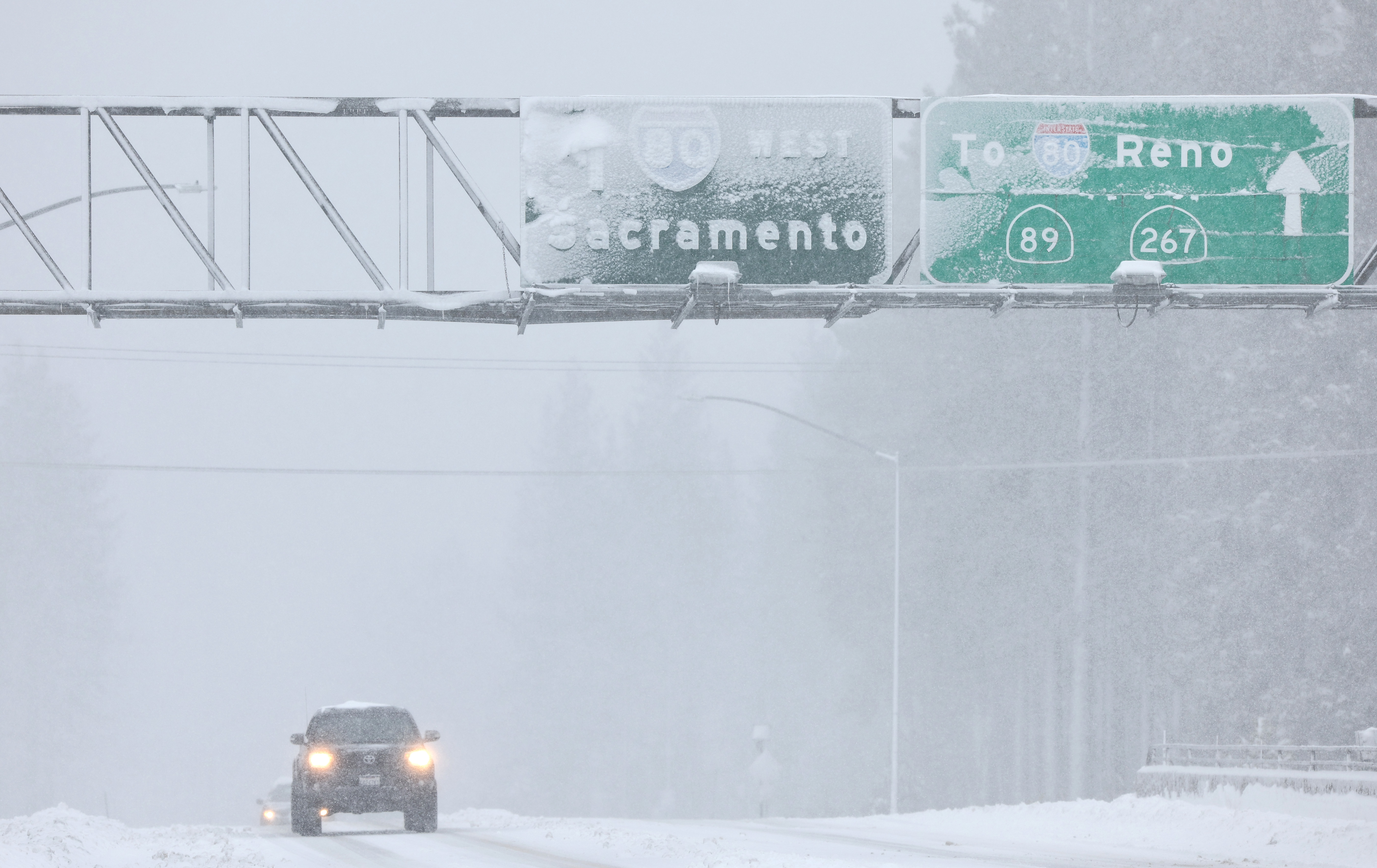 Vehicles drive as snow falls north of Lake Tahoe in the Sierra Nevada mountains during a powerful winter storm in Truckee, California, on March 1, 2024 | Source: Getty Images