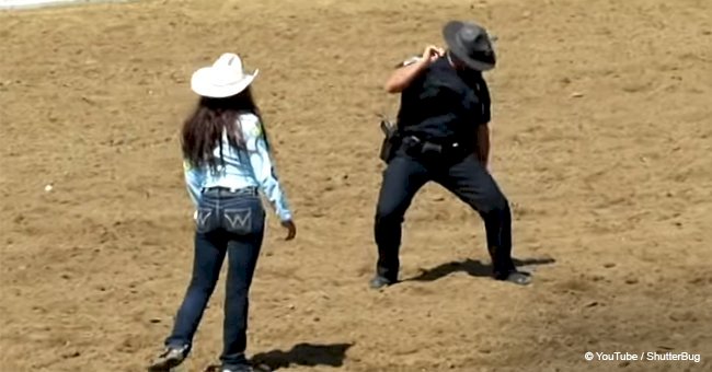 Cop takes part in a dance battle with a cowgirl making the Rodeo erupt with his first move