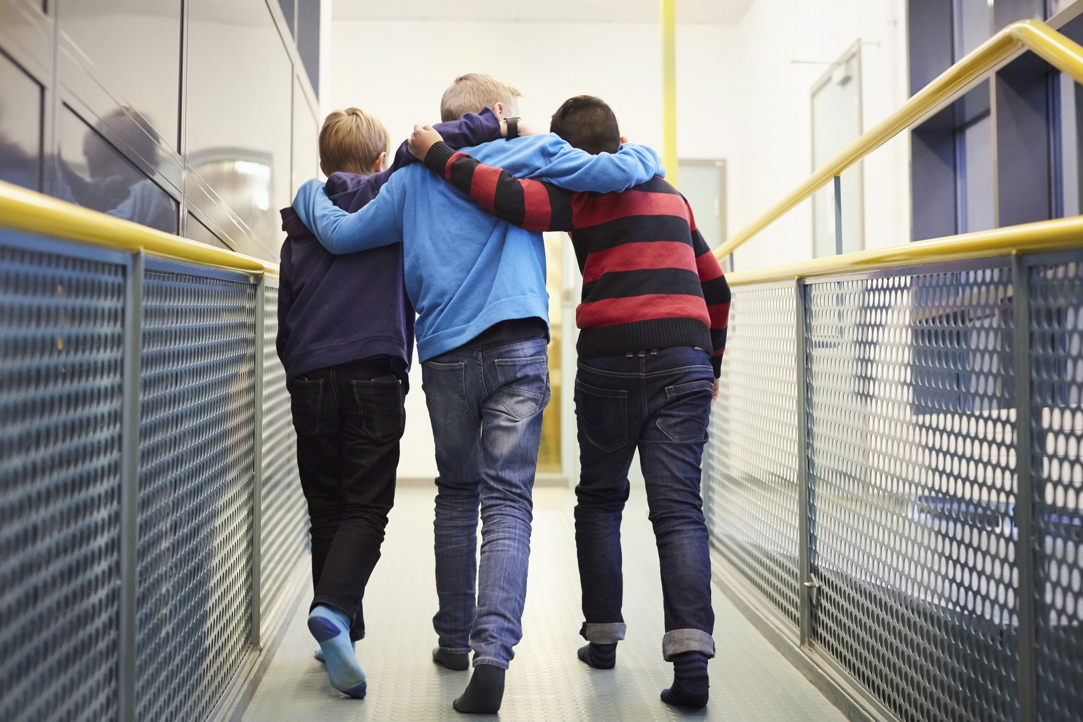 Tres niños caminan abrazados. | Foto: Getty Images