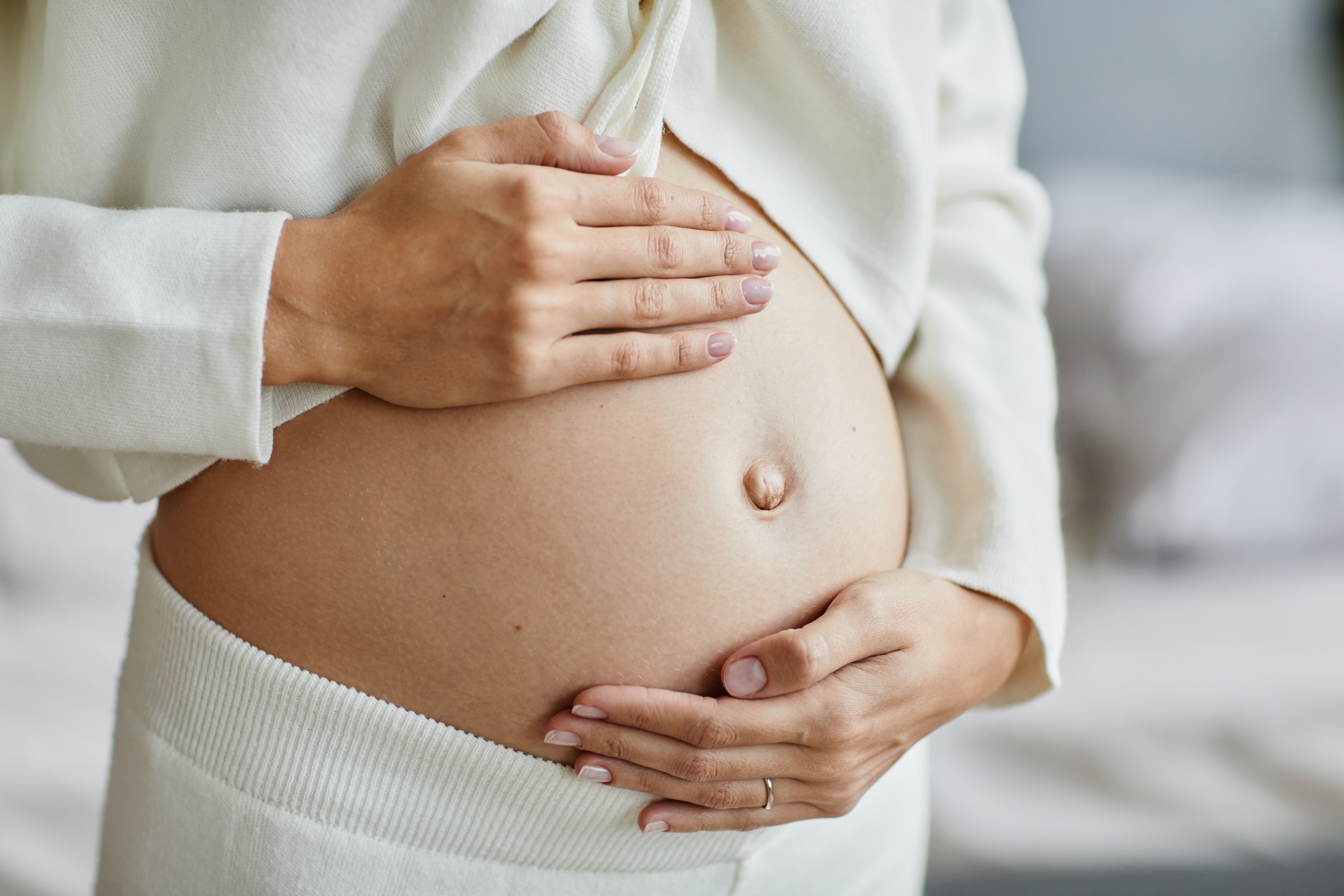 A pregnant woman cradling her stomach | Source: Shutterstock