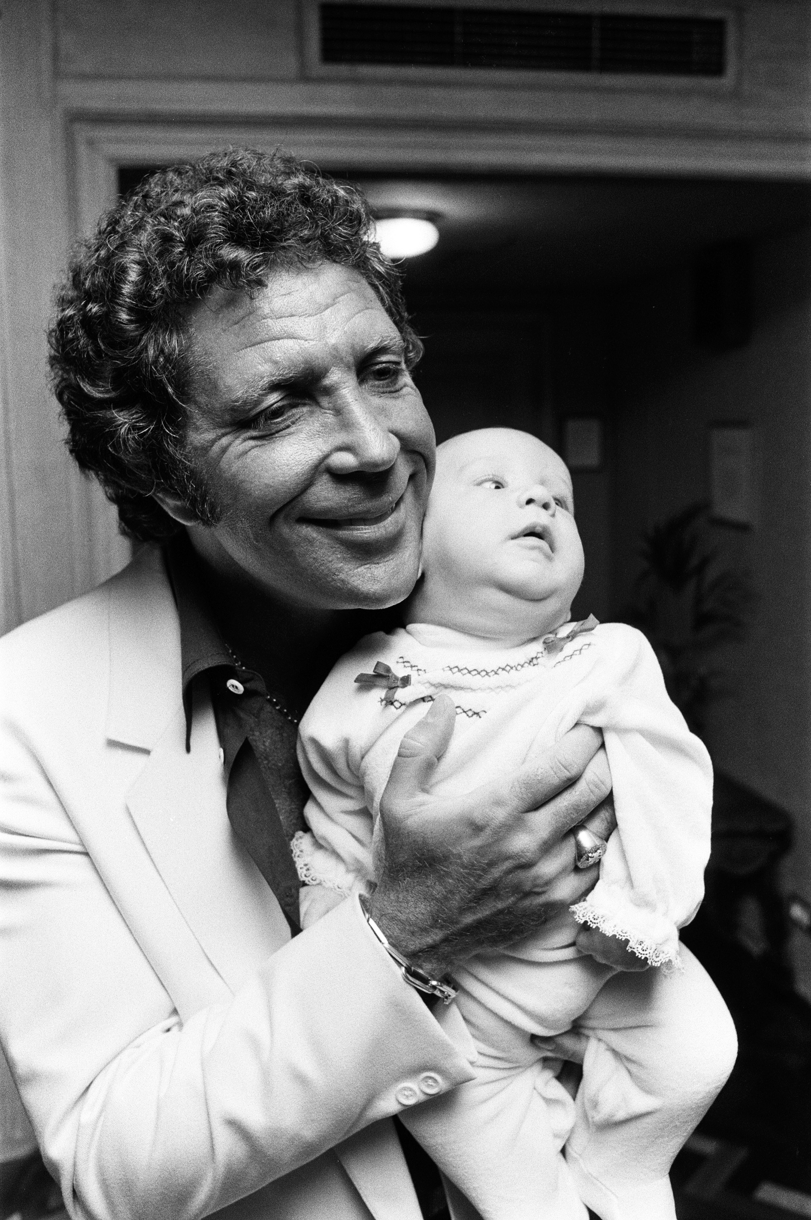 Tom Jones with his grandson Alexander, aged eleven months, in their London hotel on September 3, 1983 | Source: Getty Images