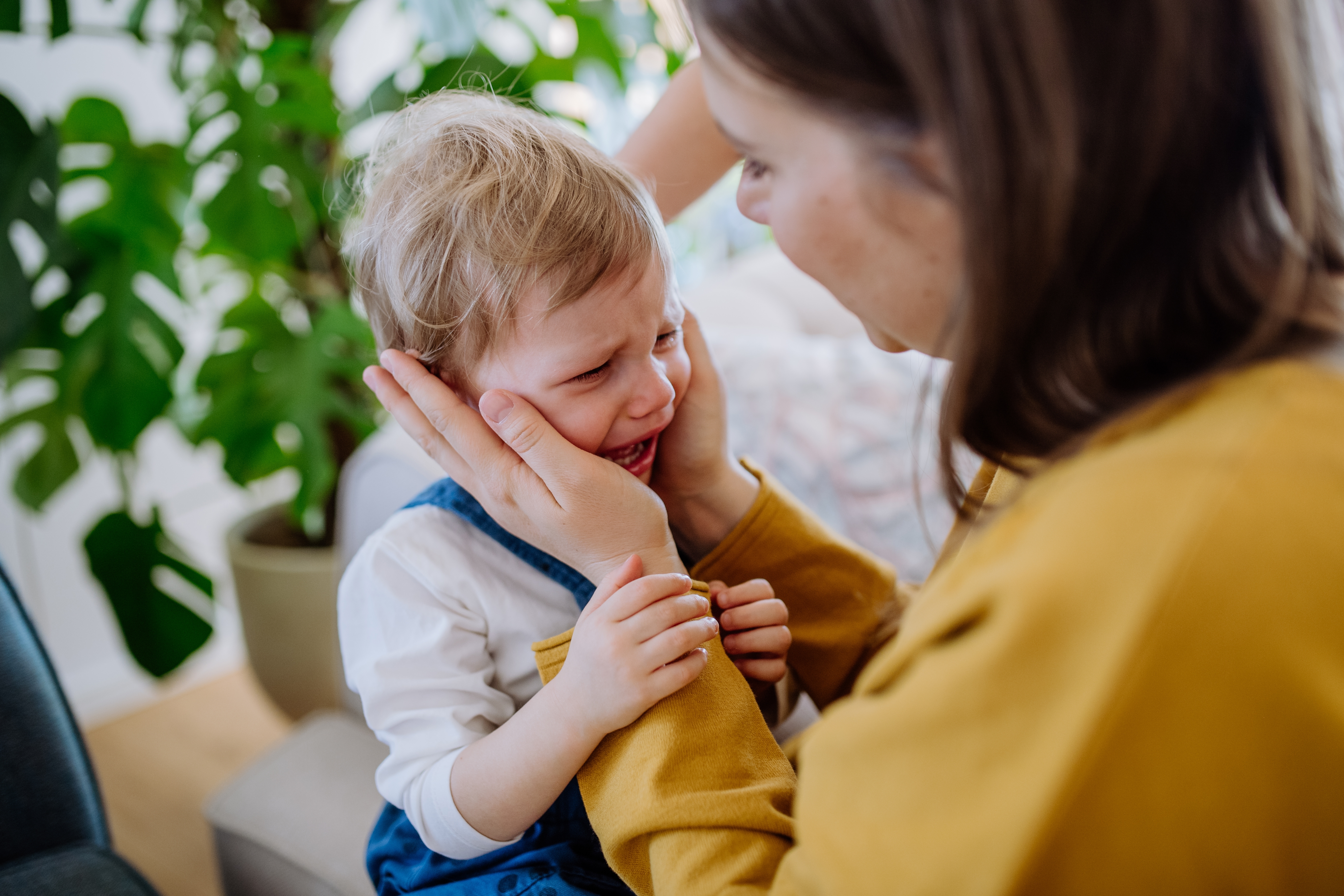 Eine Frau tröstet ein weinendes Kind | Quelle: Shutterstock