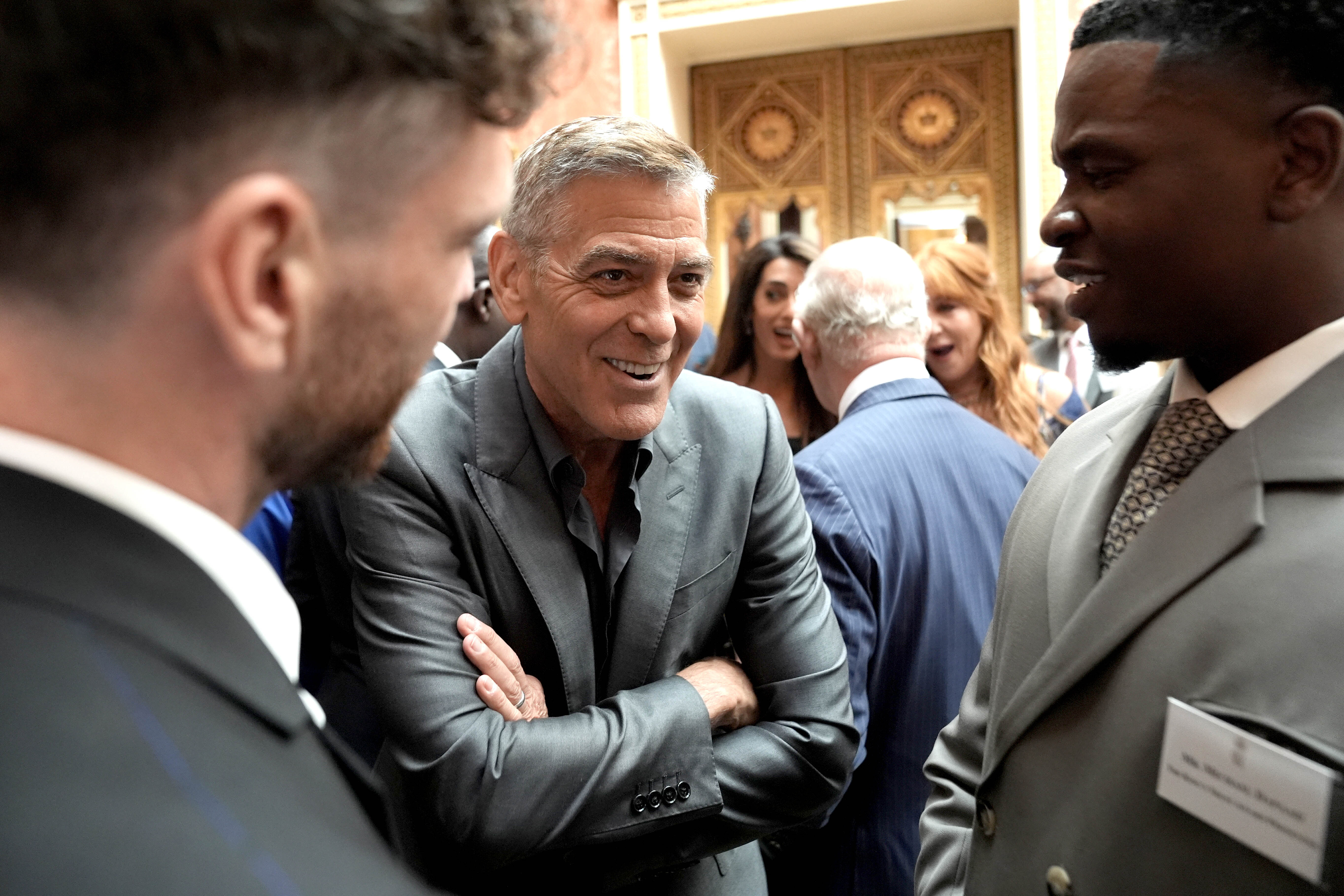 George Clooney speaks with attendees during a reception for the winners of the King's Trust Awards at Buckingham Palace | Source: Getty Images