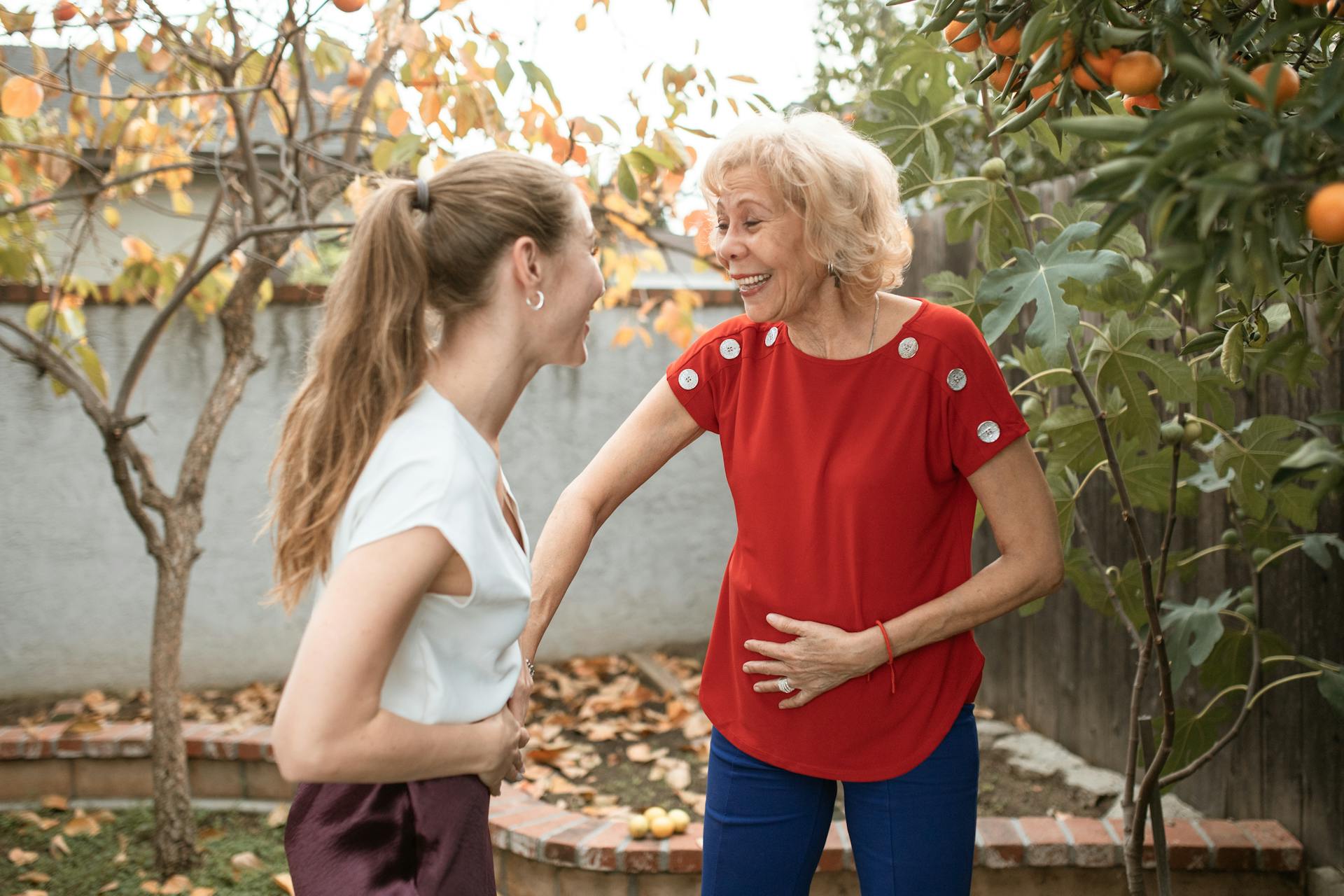 A blonde woman with a ponytail chatting with a senior lady in the garden | Source: Pexels