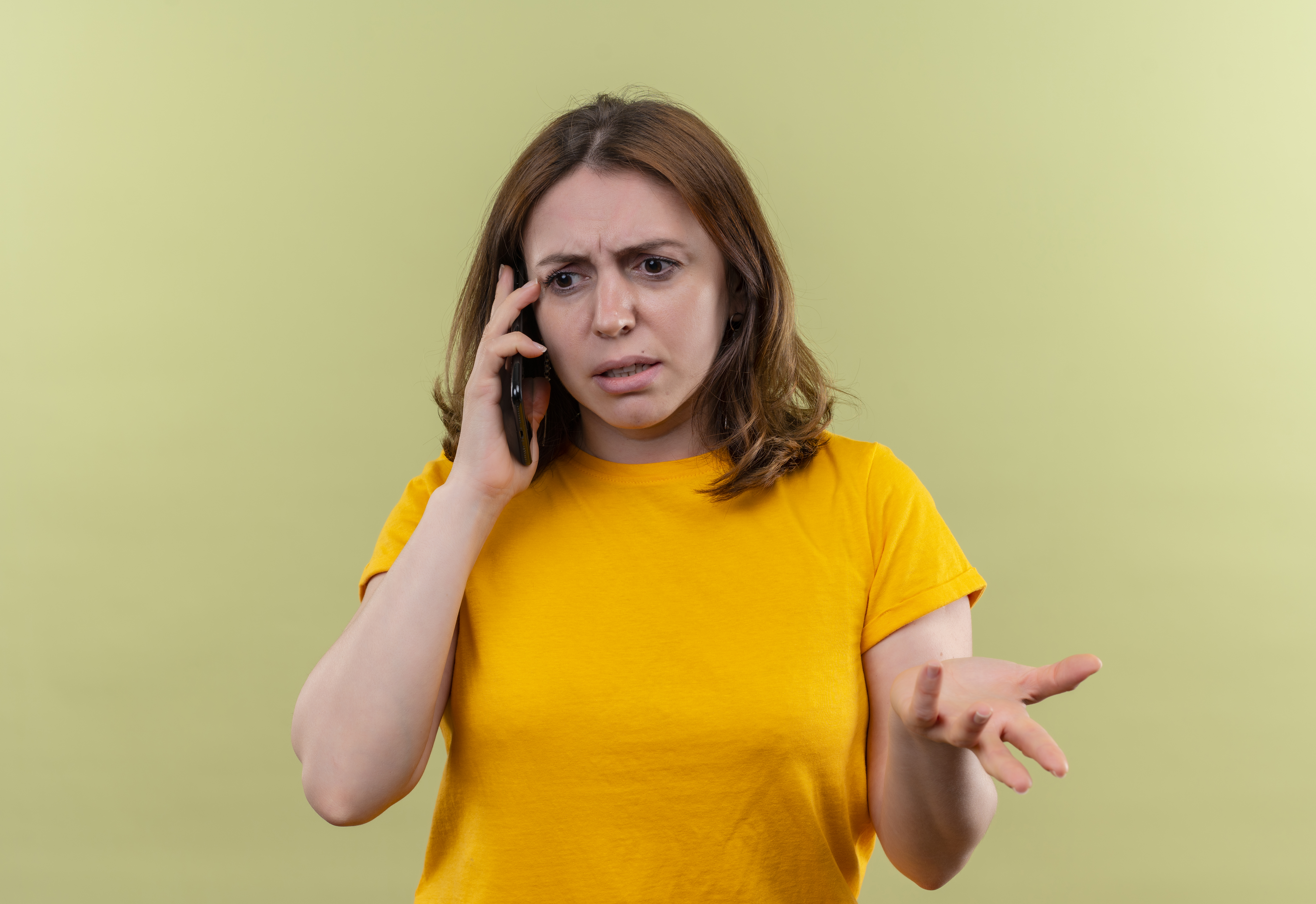 Woman looking unpleased as she talks on the phone | Source: Freepik