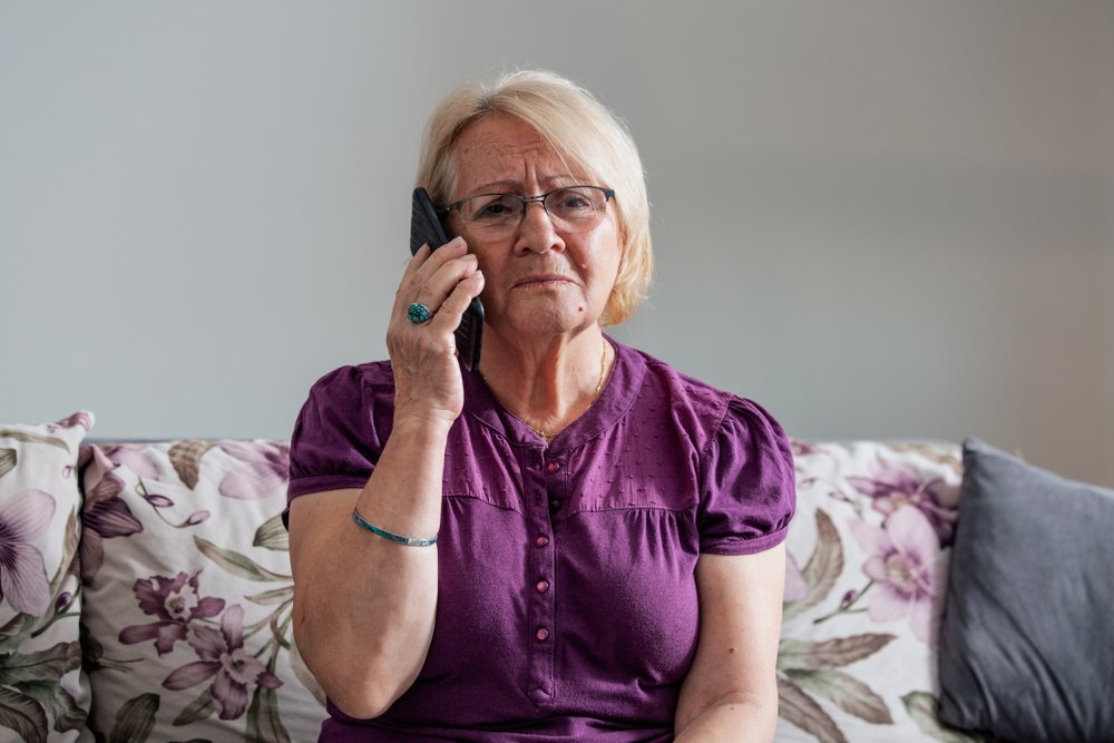 Señora escucha preocupada al teléfono. | Foto: Shutterstock