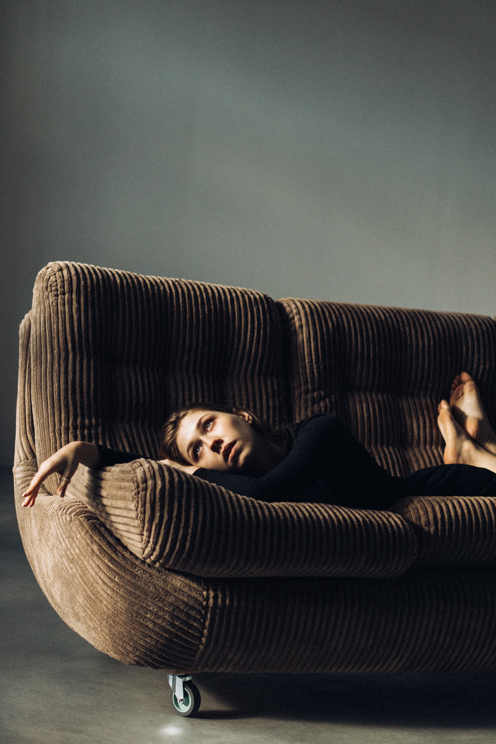 A sad woman lying on a sofa | Source: Pexels